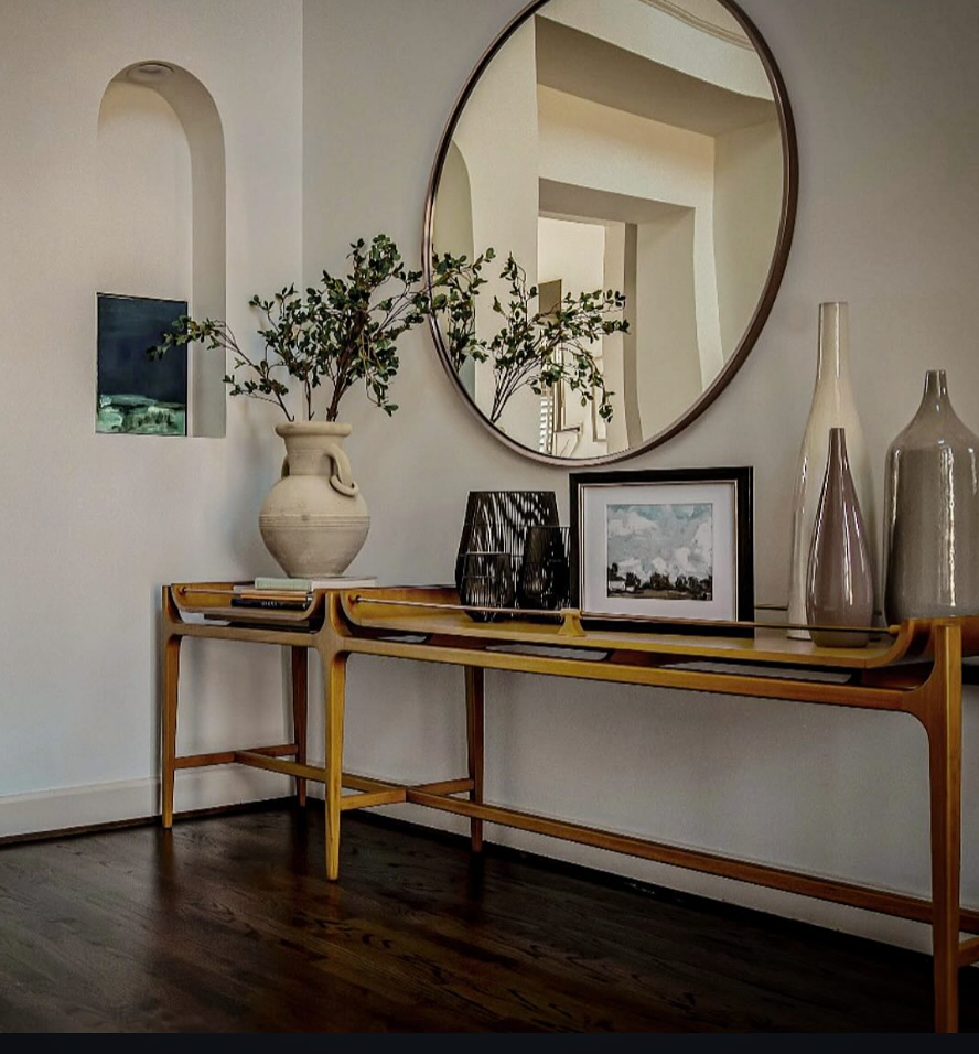 Console table vignette designed by Studio Black Oak — decorative vases, round mirror, and potted plant compose a sophisticated entry styling