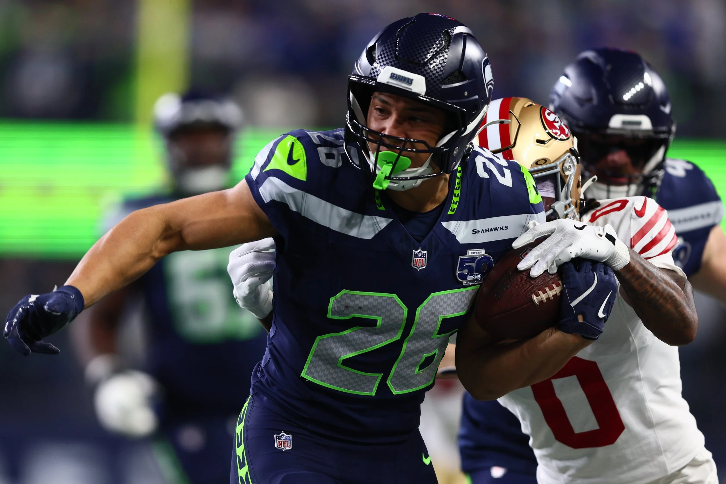Seattle Seahawks running back Zach Charbonnet (26) carries the ball as San Francisco 49ers cornerback Renardo Green (0) defends during the first half in an NFC Divisional Round game at Lumen Field. Mandatory Credit: Kevin Ng-Imagn Images