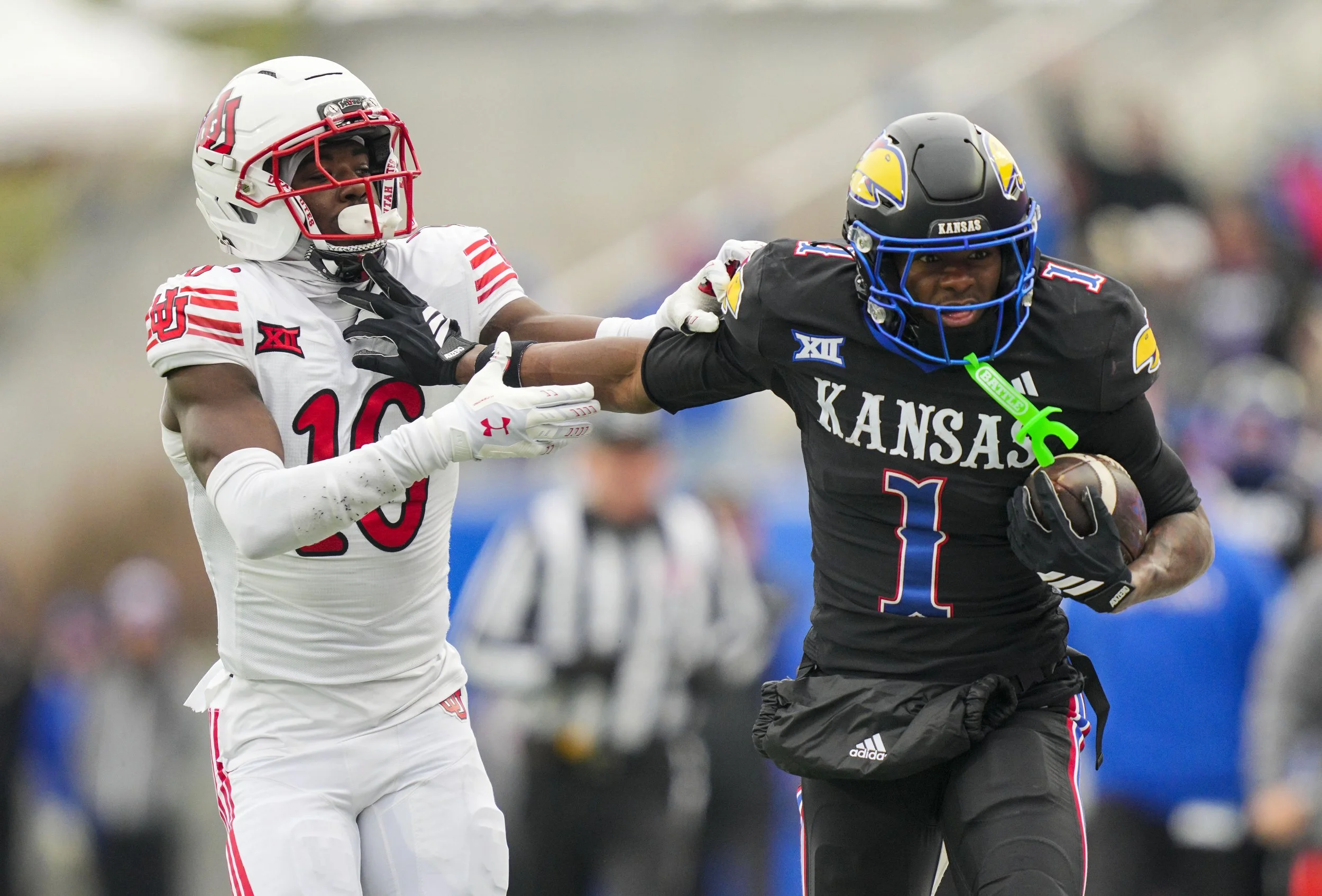 Kansas Jayhawks wide receiver Emmanuel Henderson Jr. (1) runs with the ball against Utah Utes cornerback Blake Cotton (16) during the second half at David Booth Kansas Memorial Stadium. Mandatory Credit: Jay Biggerstaff-Imagn Images