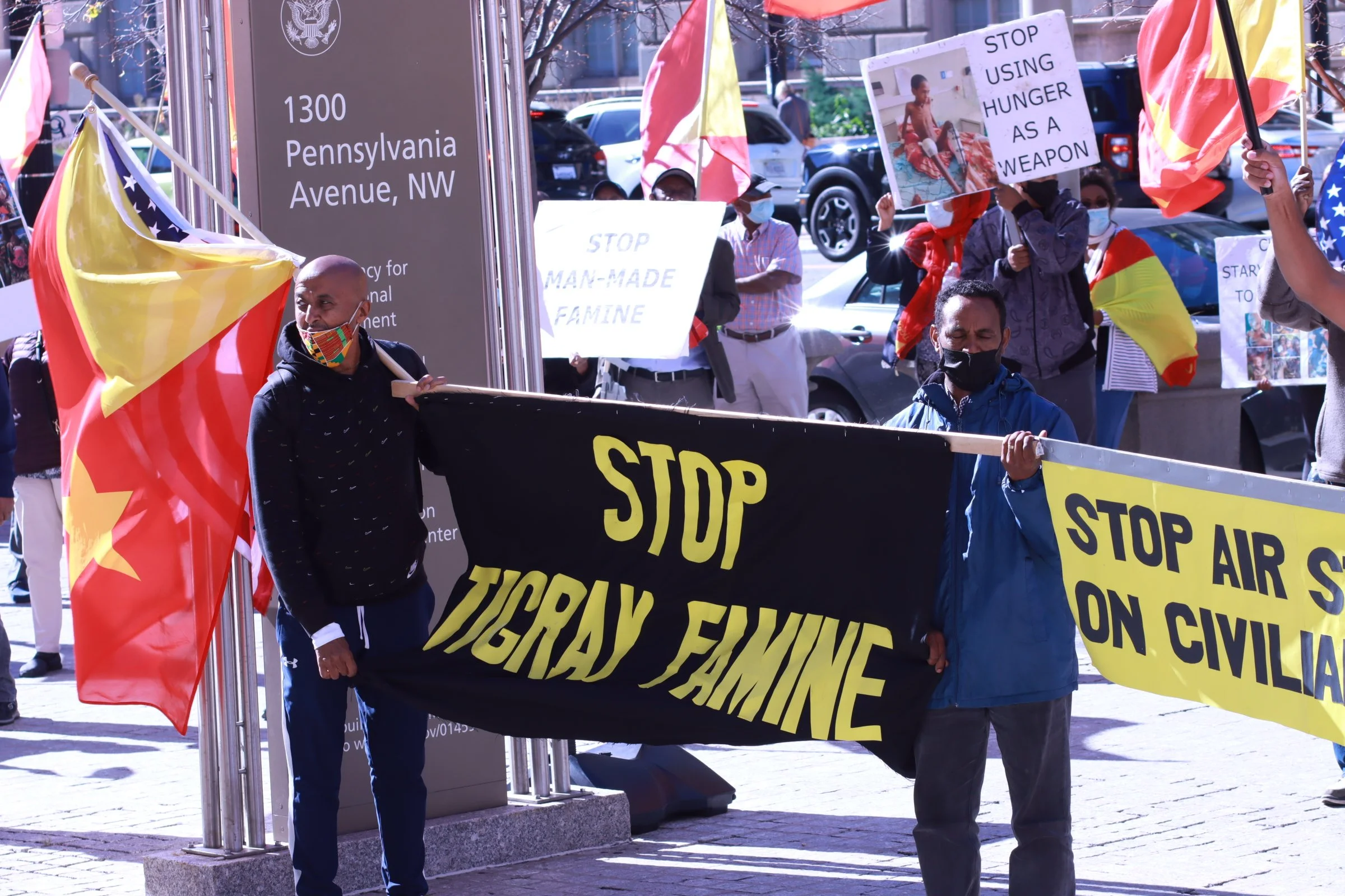 tigray ethiopian protest in washington dc during biden presidency 1300 pennsylvania ave, nw men holding sign to stop tigray famine