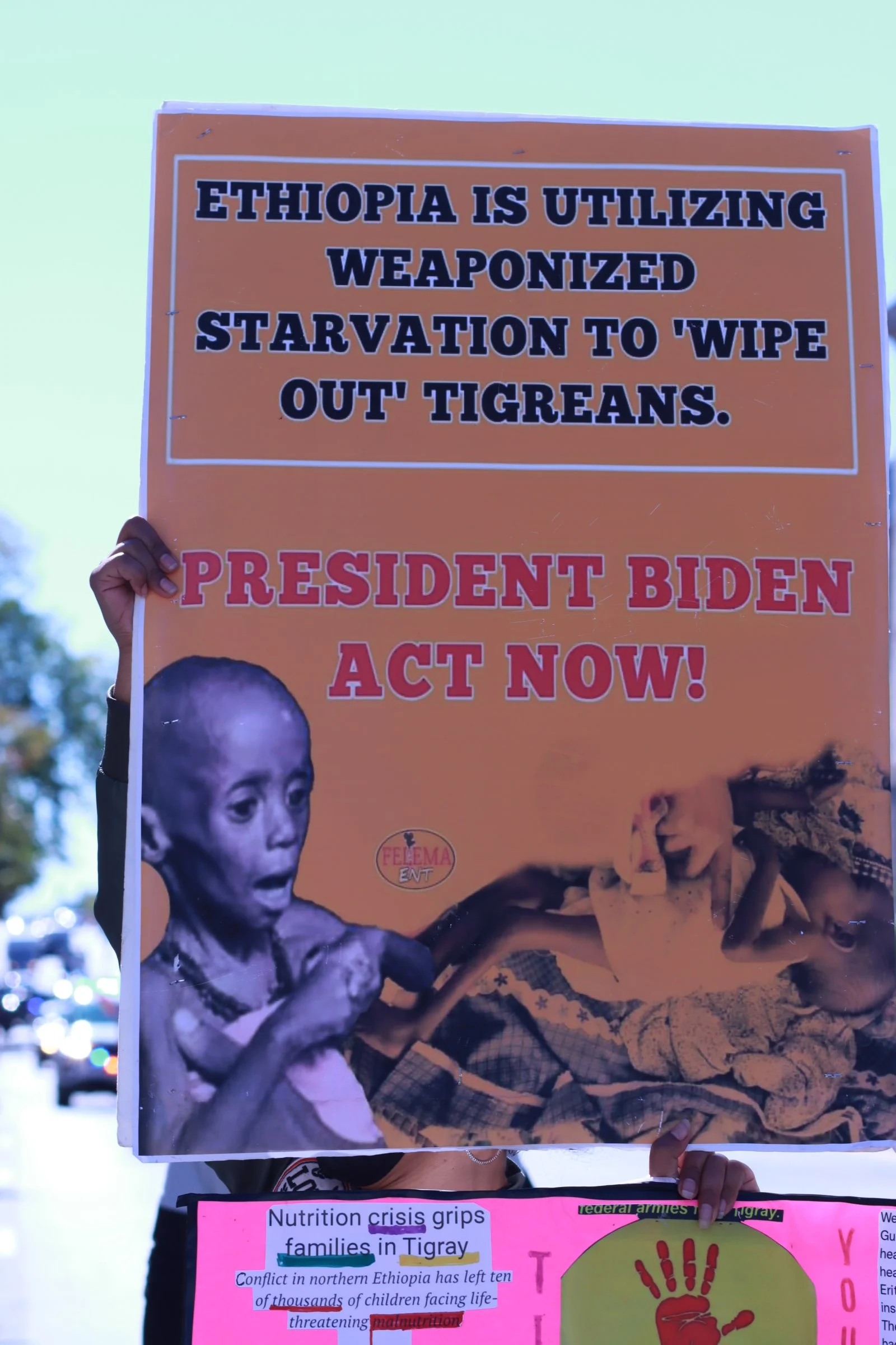 tigray ethiopian protest in washington dc during biden presidency a man holding a sign of a child malnourished asking president biden to act now
