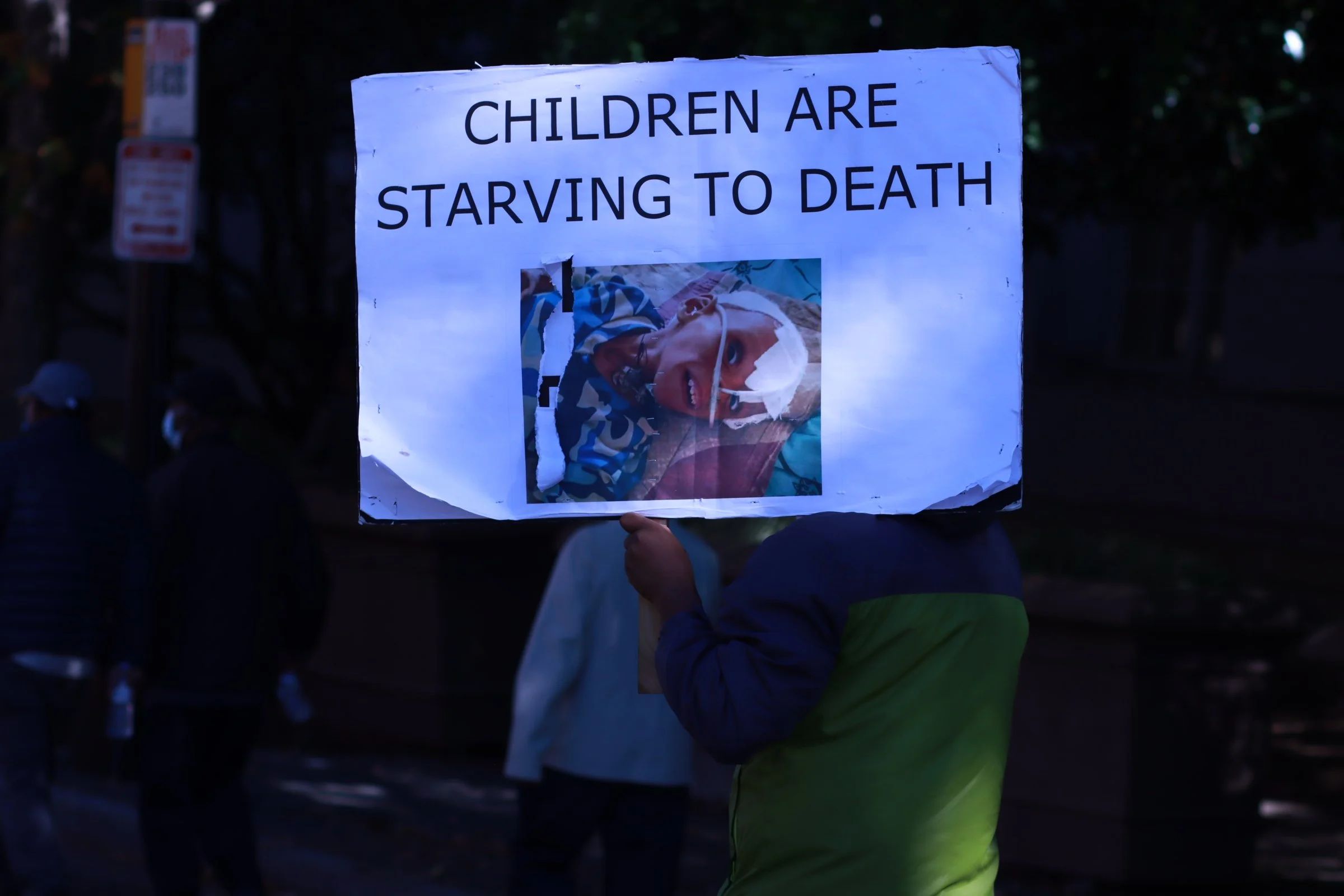 tigray ethiopian protest in washington dc during biden presidency woman holding a sign of children starving in tigray ethiopia