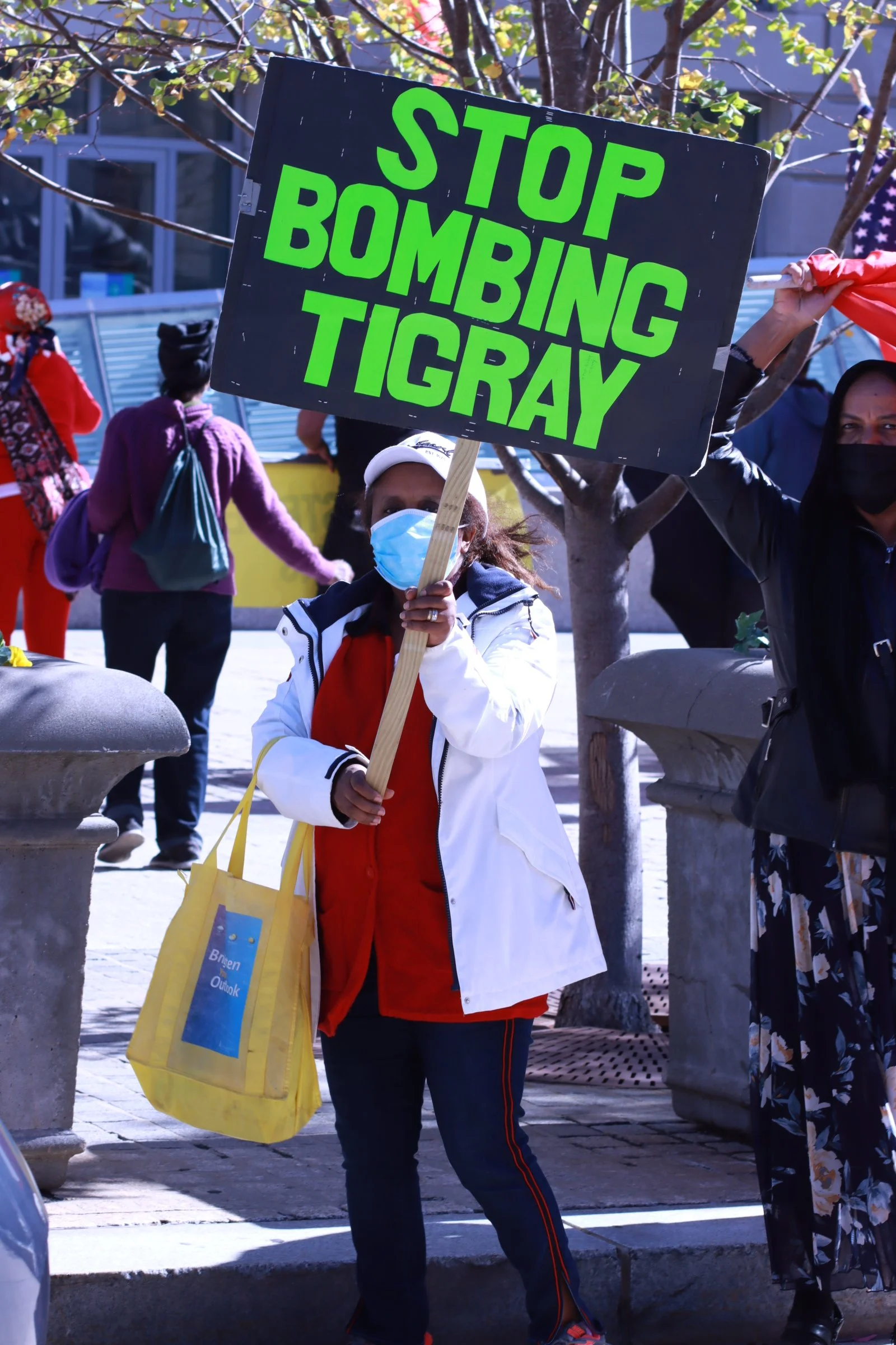 tigray ethiopian protest in washington dc during biden presidency a woman holding a sign saying stop bombing tigray