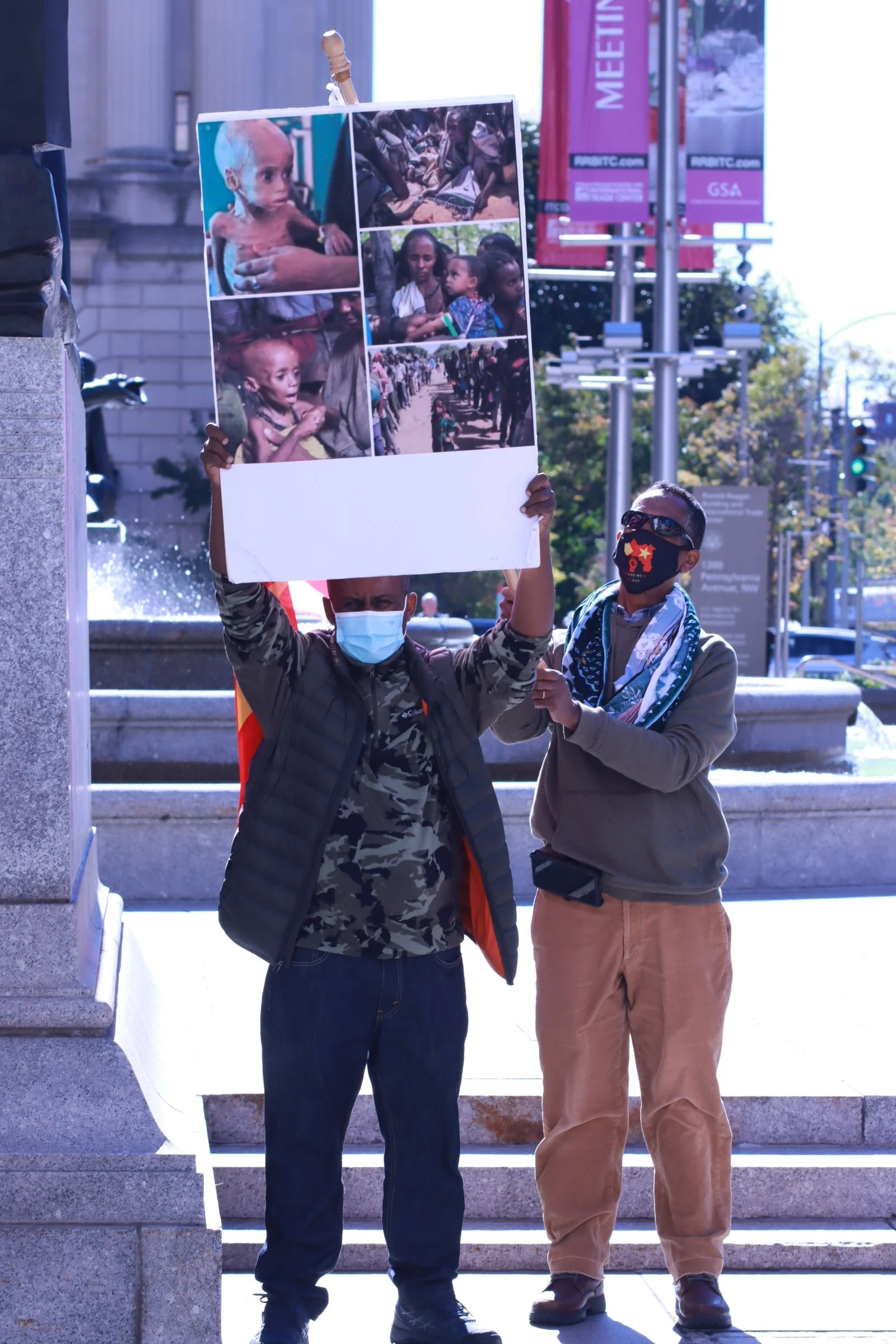 tigray ethiopian protest in washington dc during biden presidency. men holding signs supporting tigray