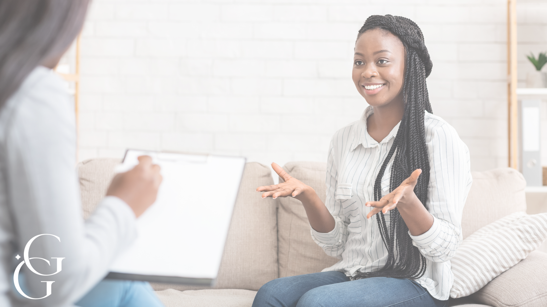 A woman smiling during a therapy or counseling session with a therapist taking notes.