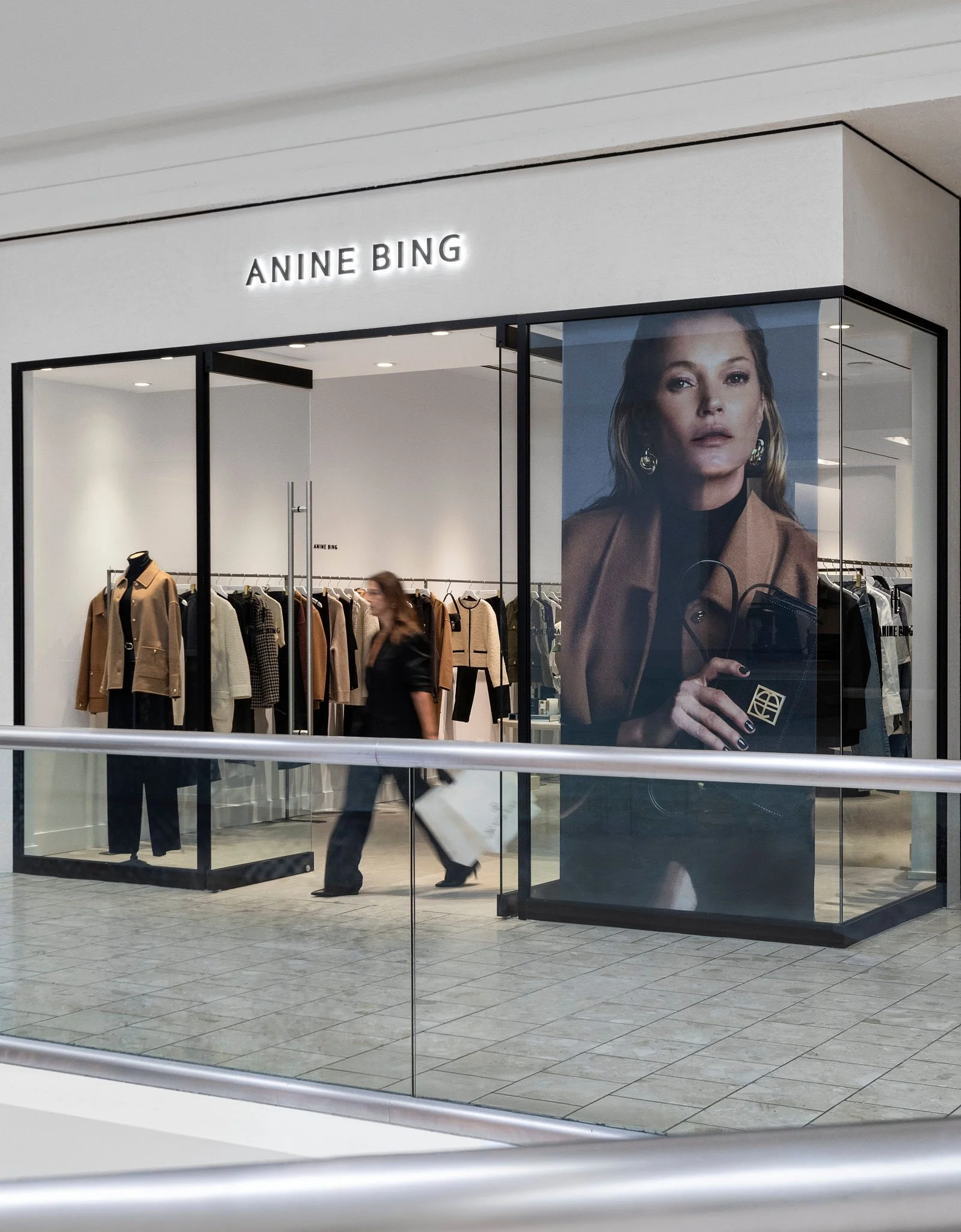 Anine Bing retail store exterior with glass walls, minimalist signage, and high-fashion campaign featuring Kate Moss.