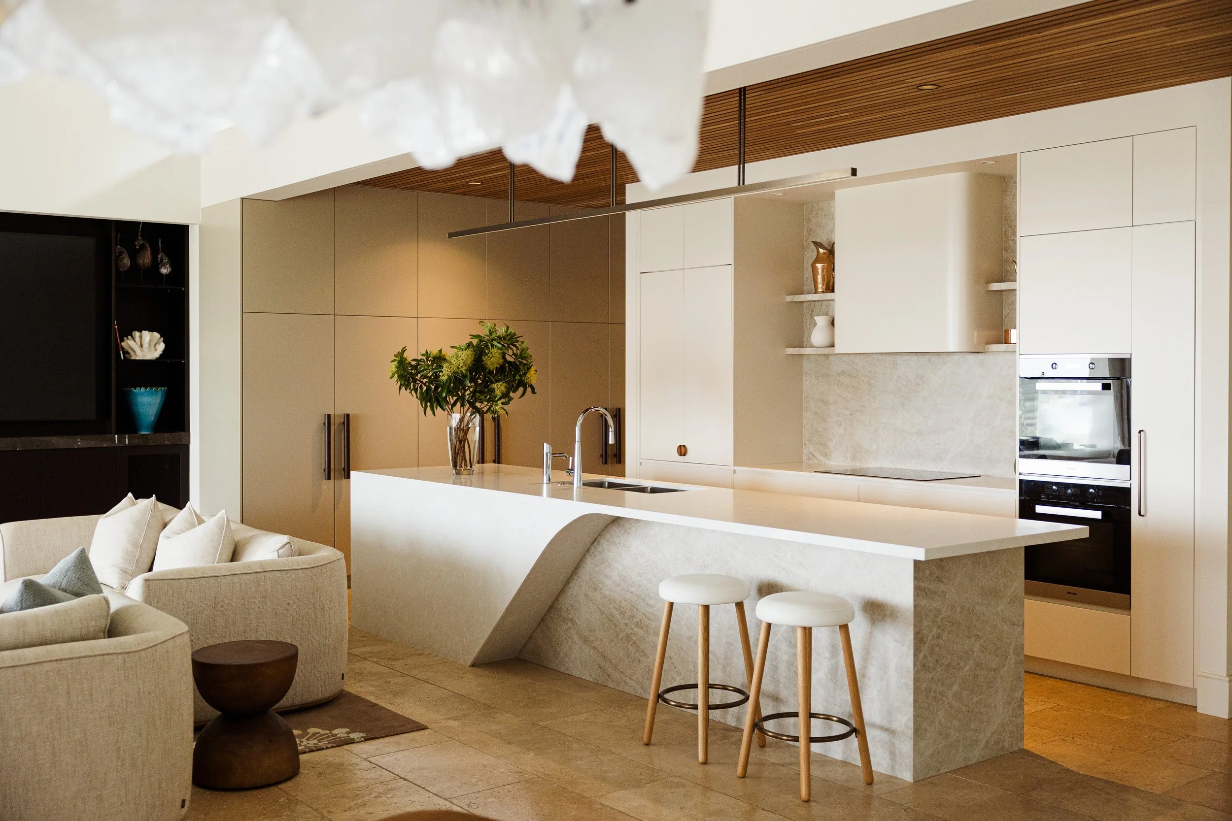 Luxury custom kitchen with Taj Mahal quartzite benchtops, curved island, integrated appliances and handcrafted joinery in Freshwater.