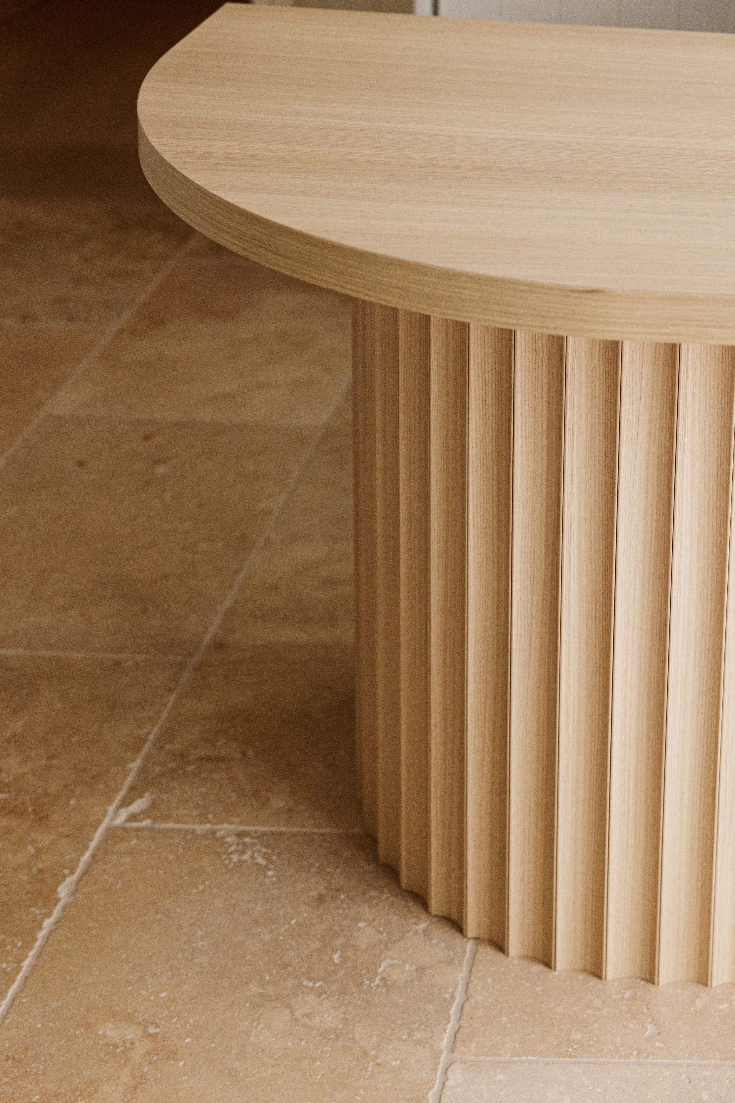 custom office desk with round base panelling and natural stone flooring