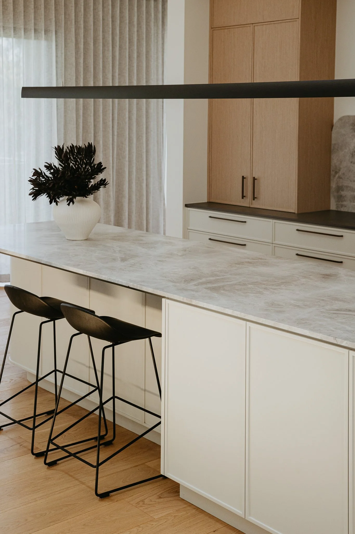 Designer kitchen with a statement island, concealed storage, and neutral finishes, combining modern aesthetics with practical family living solutions.