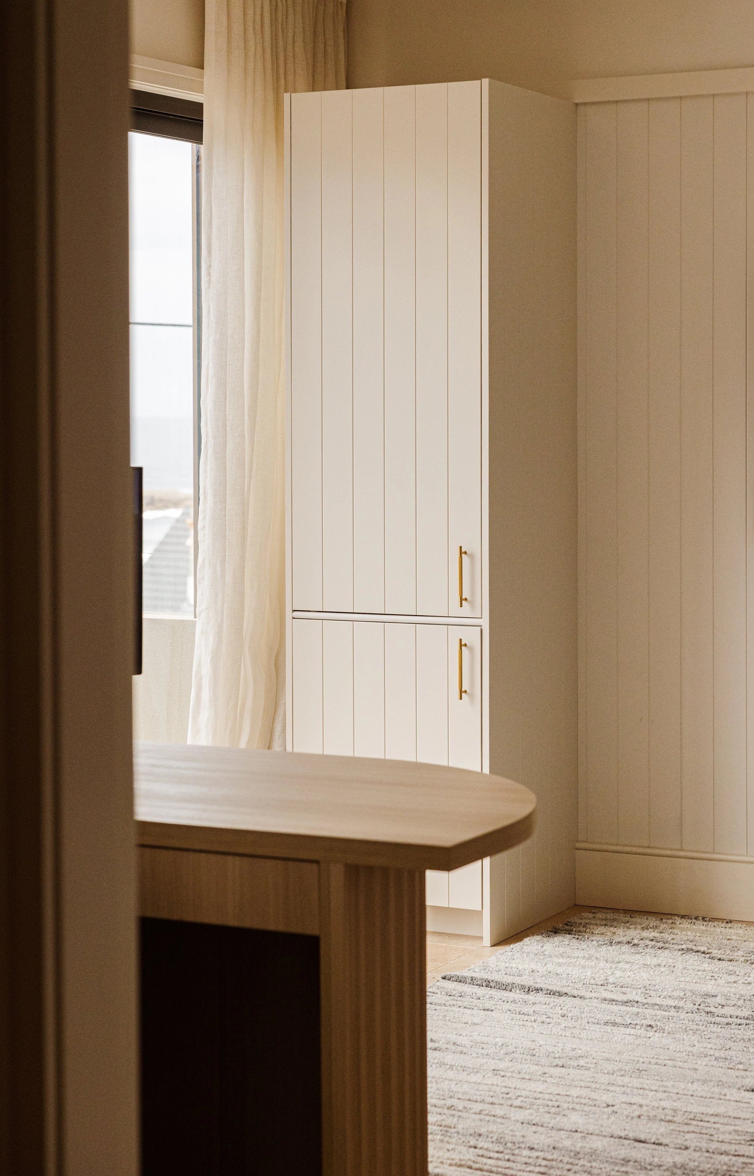 Custom home office featuring bespoke white V-groove cabinetry, timber desk and built-in storage in Freshwater.