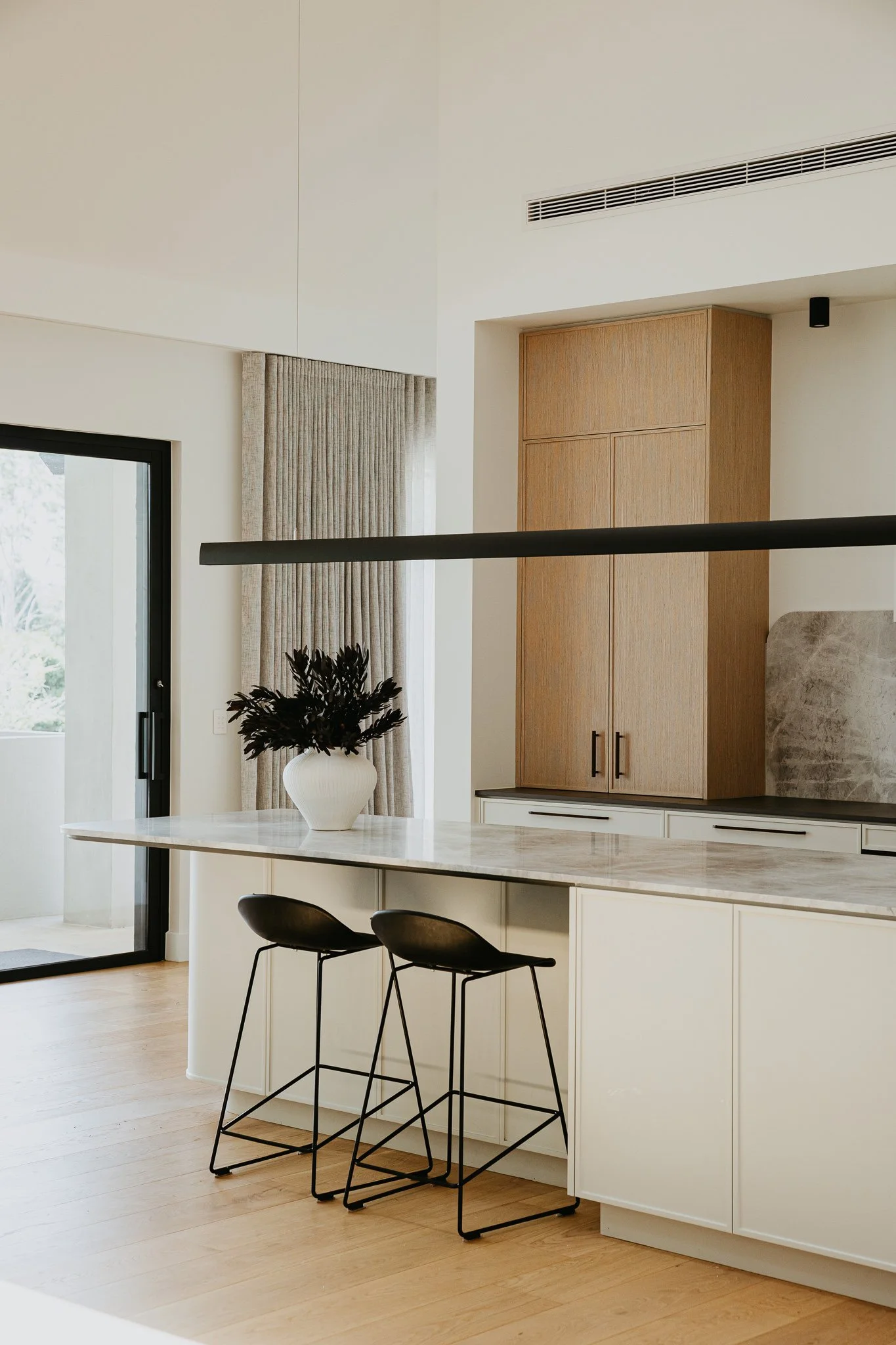 Contemporary kitchen design with clean lines, neutral palette, and a spacious island, showcasing high-end joinery and seamless built-in storage solutions.