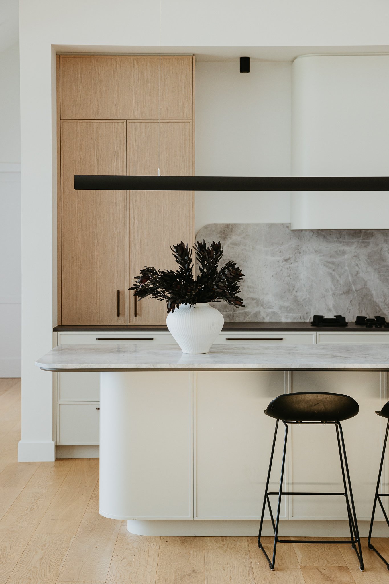 High-end kitchen interior featuring natural textures, soft lighting, and a streamlined island bench, perfect for modern Australian home design.