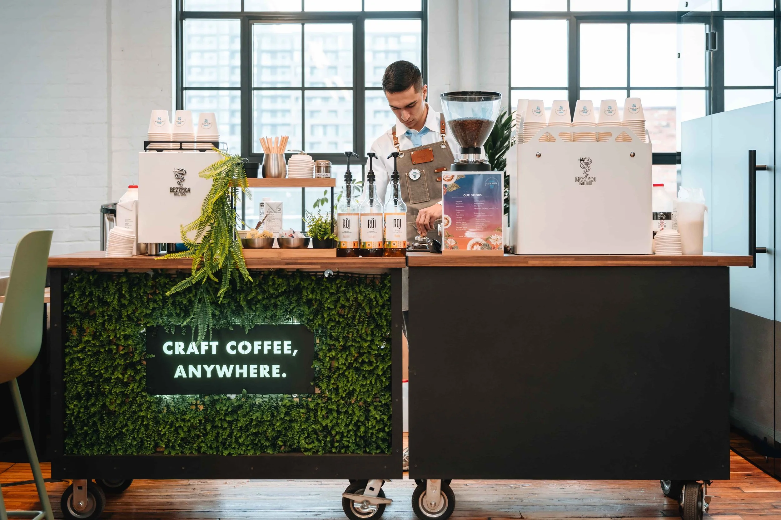A barista working on a mobile espresso bar during an office event