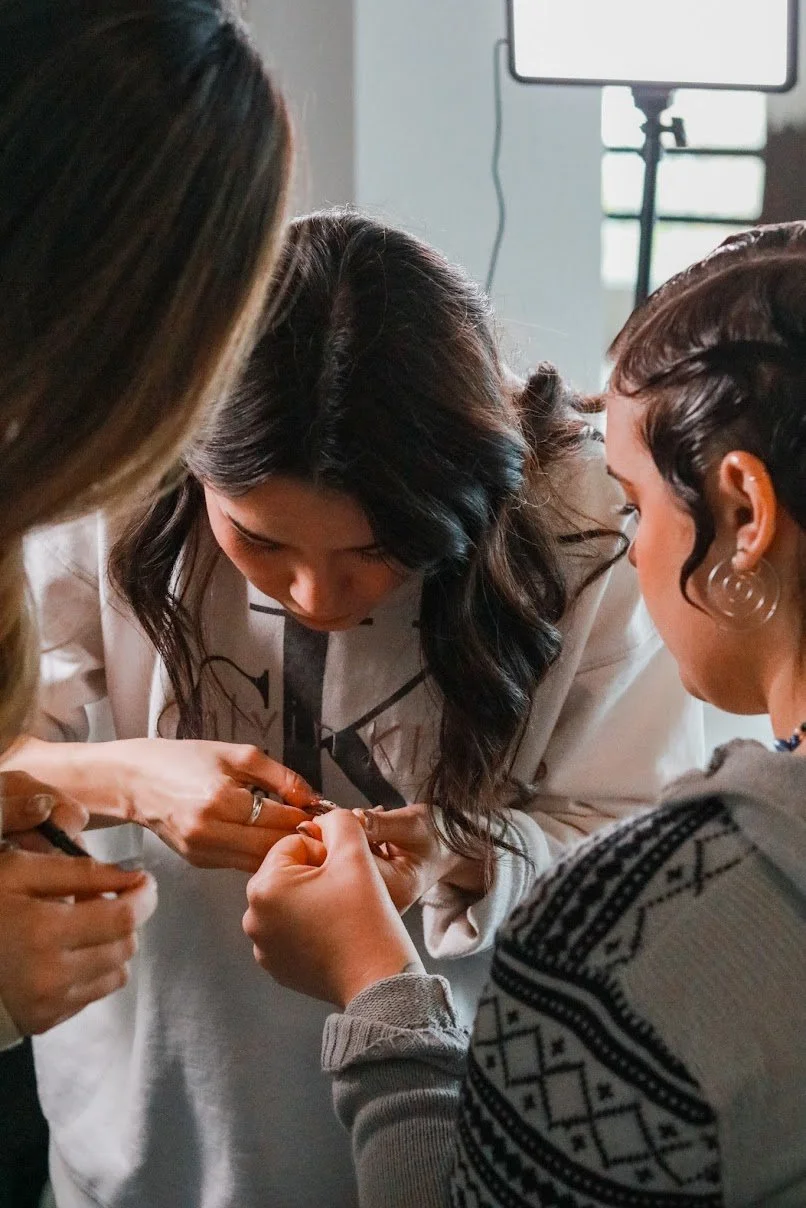 People crafting jewelry, close-up of hands working on a project.