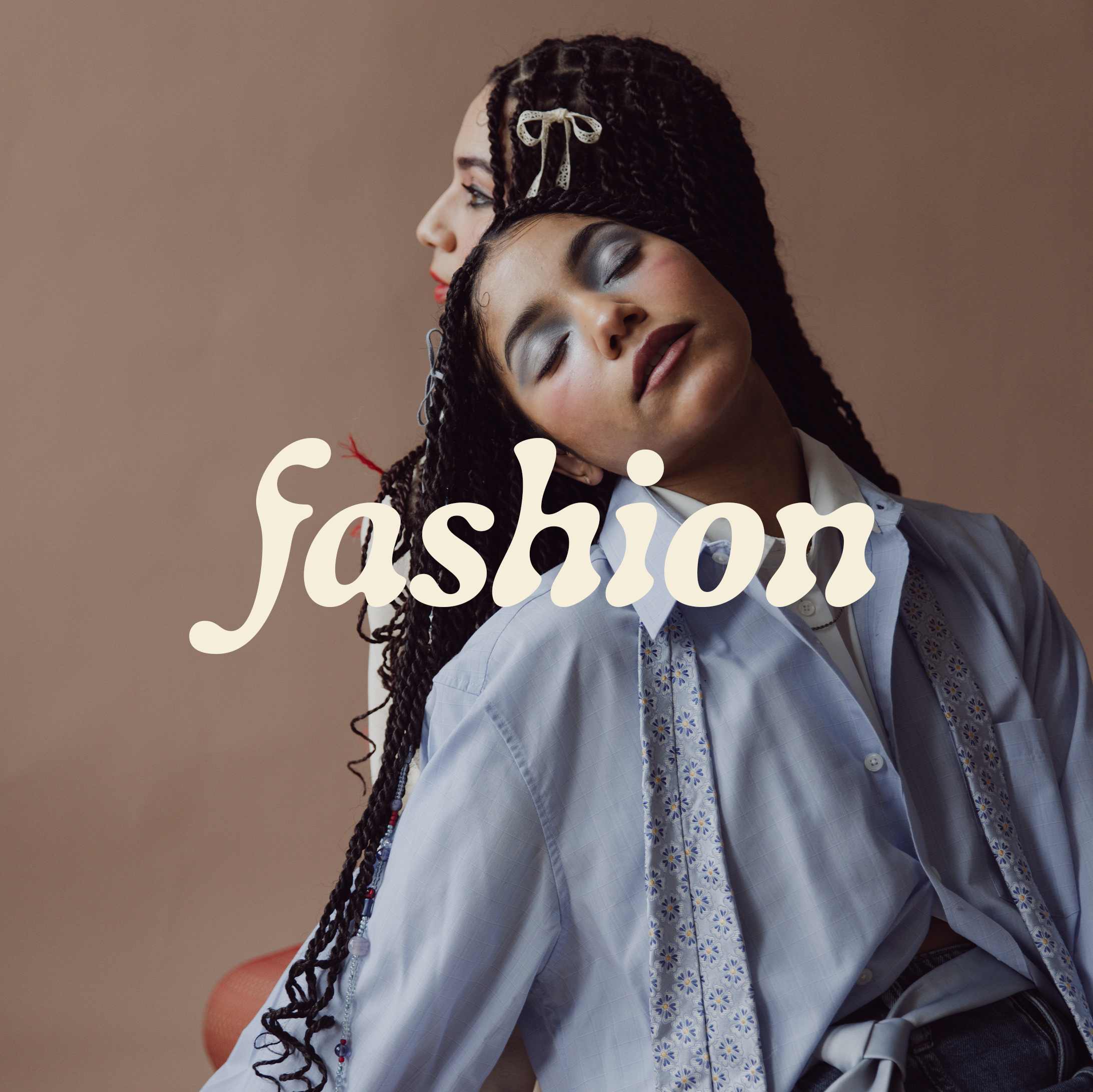 Two models with braided hair posing with "fashion" written across them.