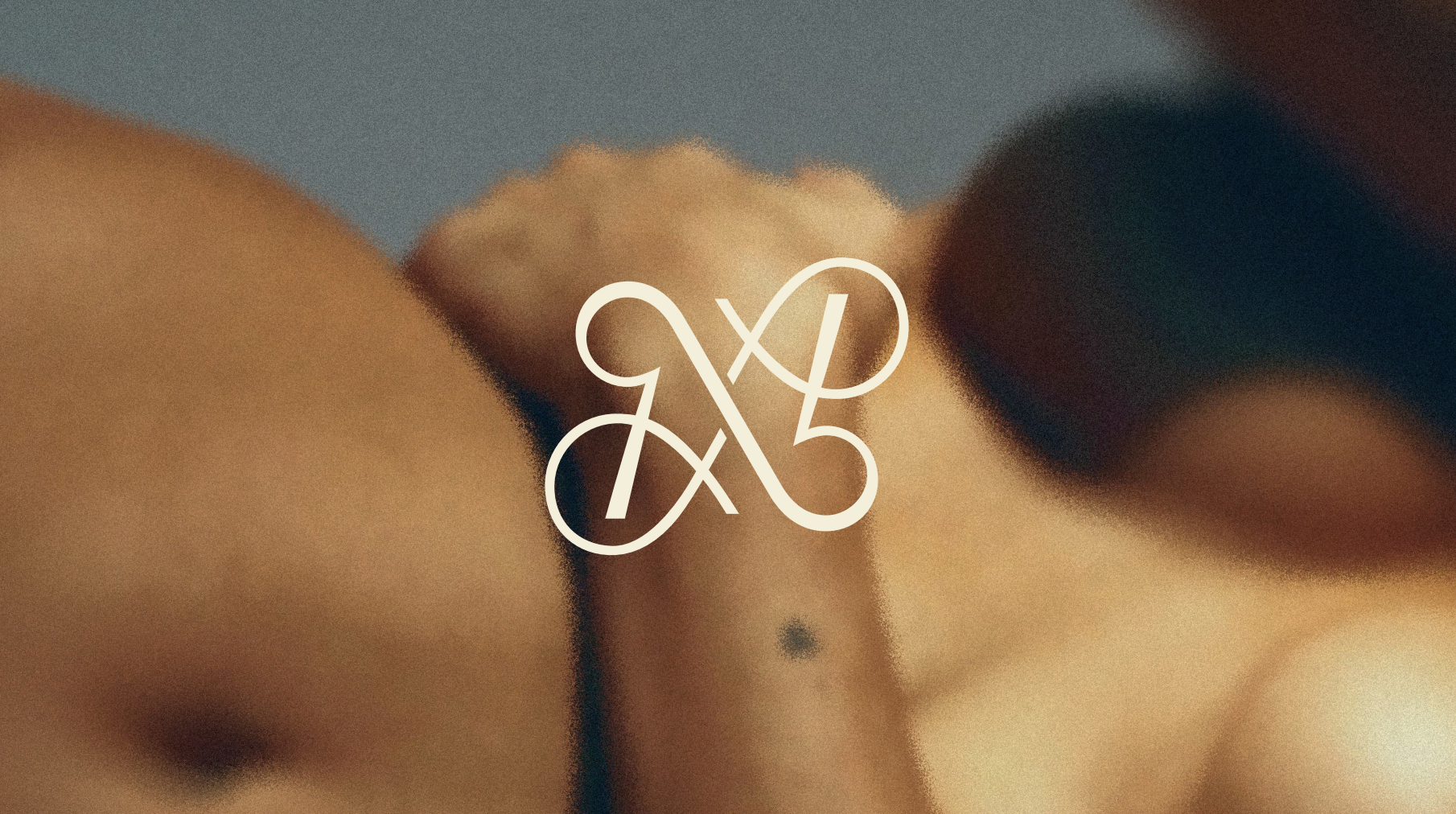 Close-up of a bare human hand with fingers touching, with the logo '9X' overlayed in white.