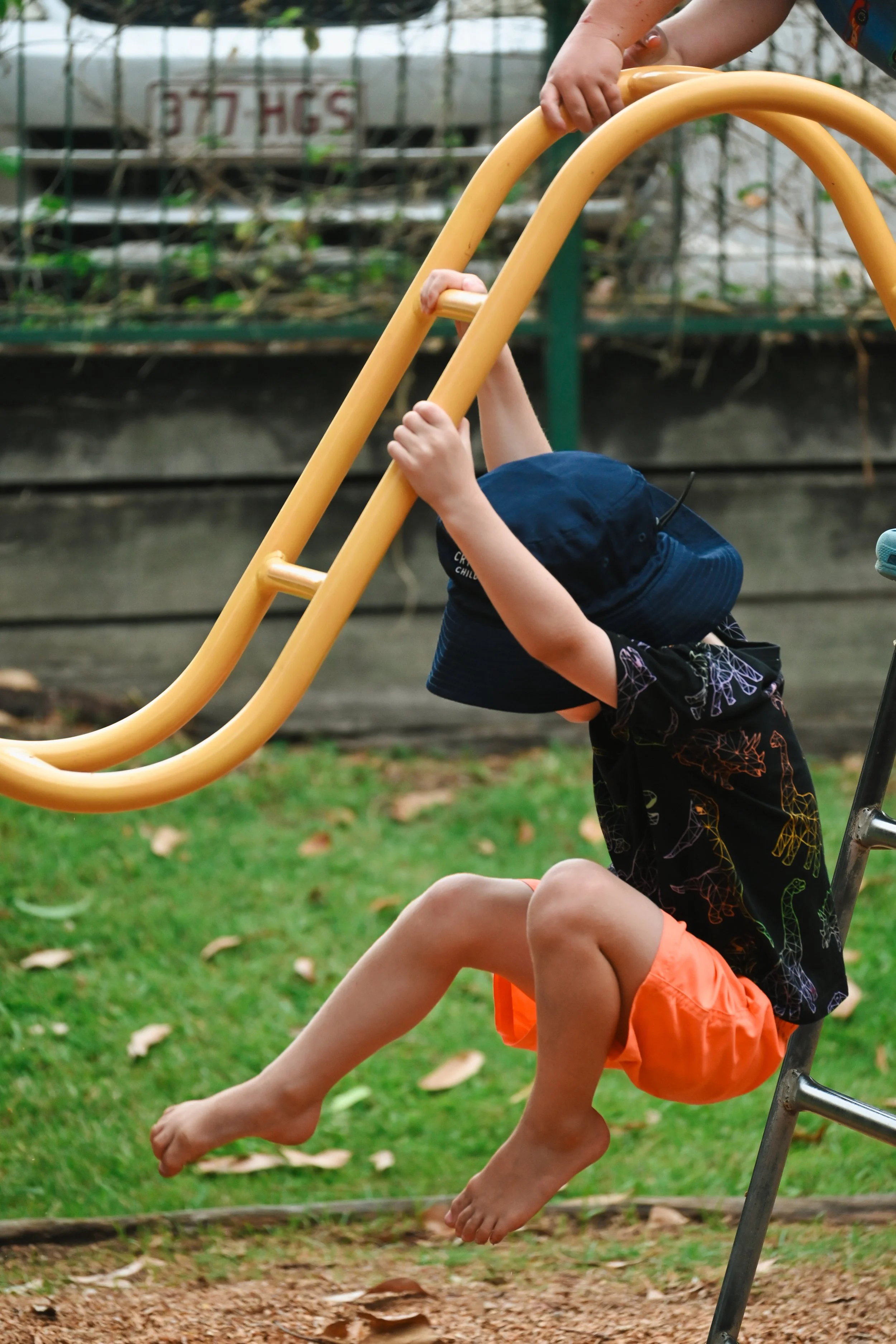 Child playing on playground monkey bars.