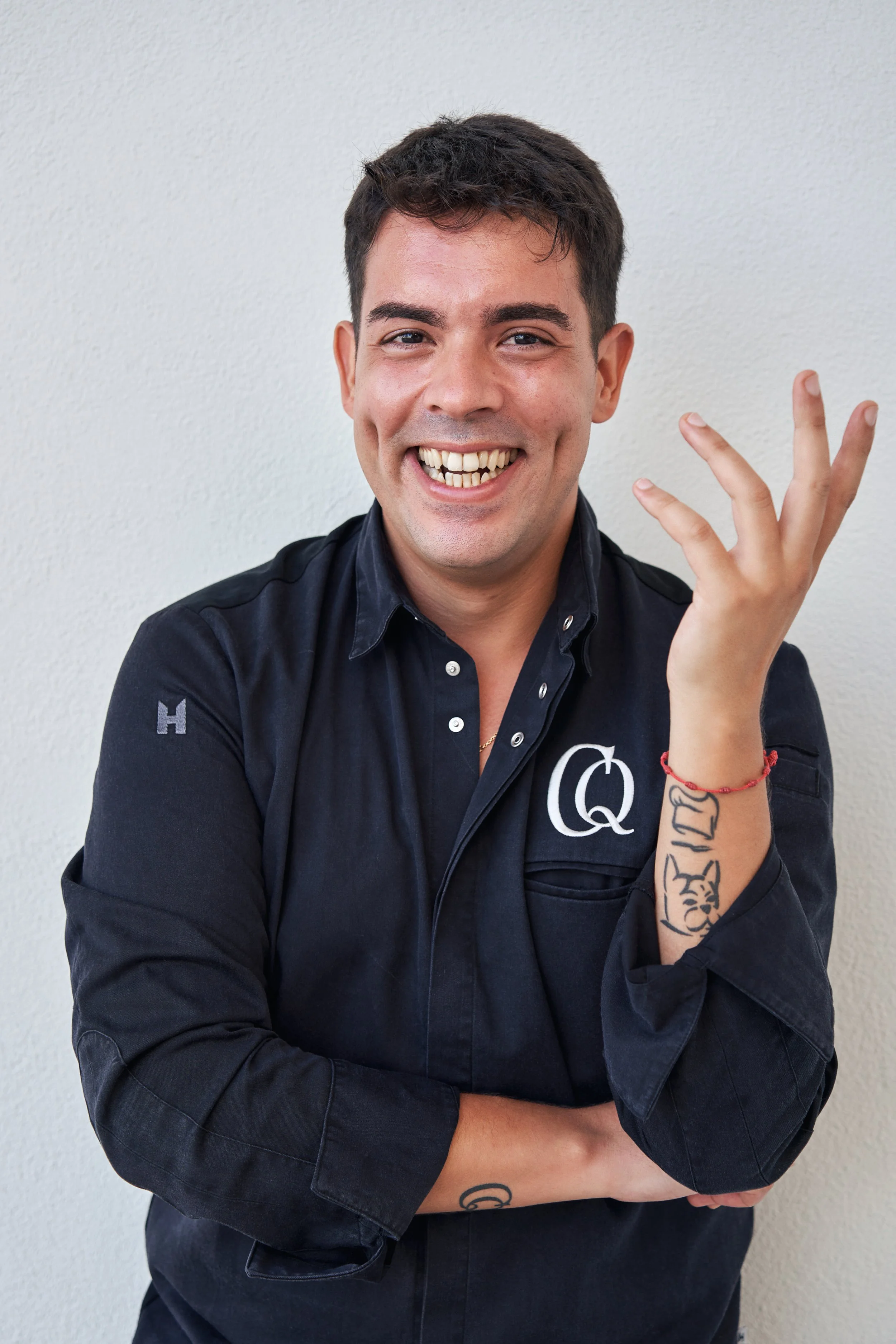 Chris Quirós smiling in chef jacket with CQ logo, showcasing culinary branding — private chef and gastronomic strategist based in Brisbane.