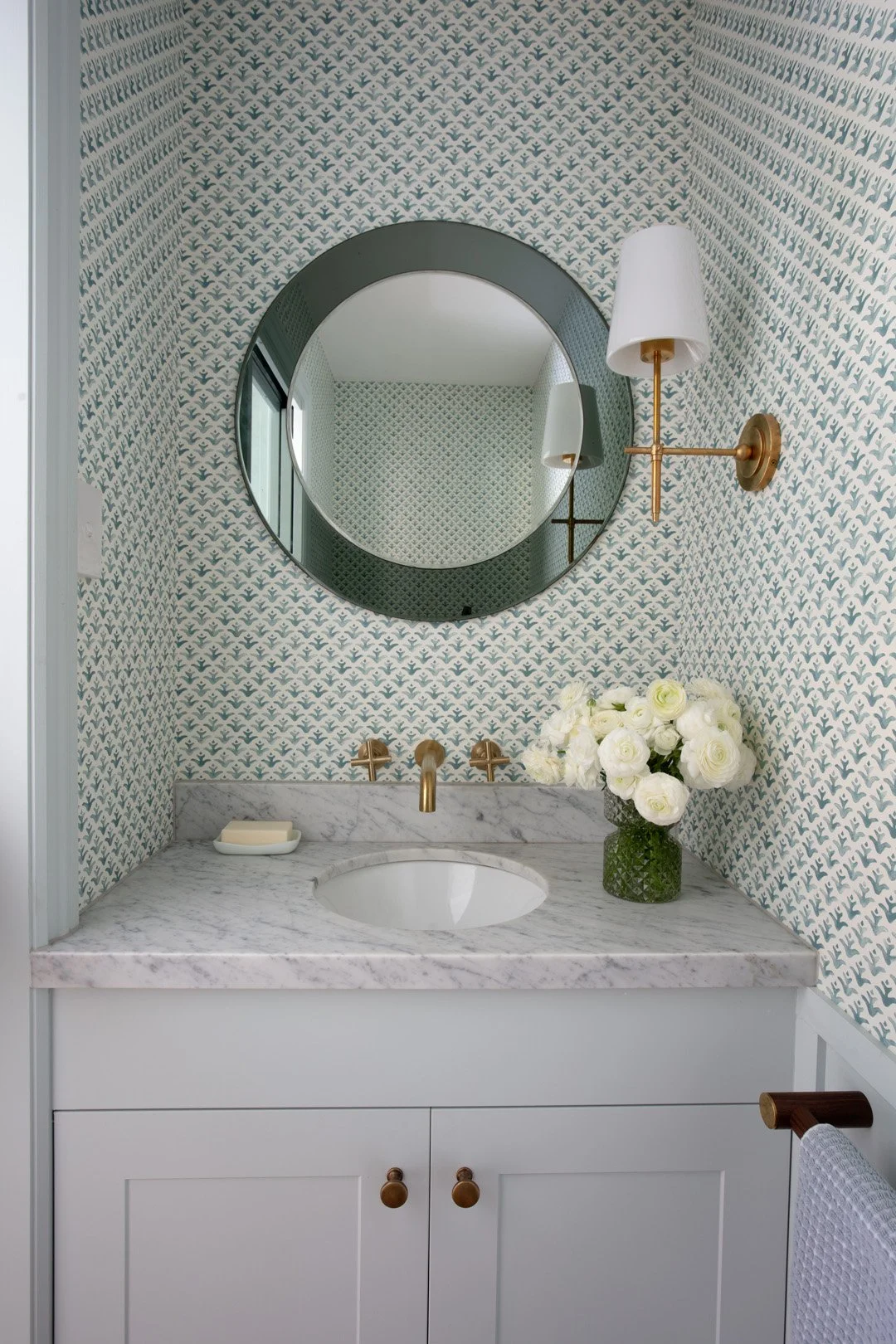 Pretty powder room with wallpaper and italian mirror