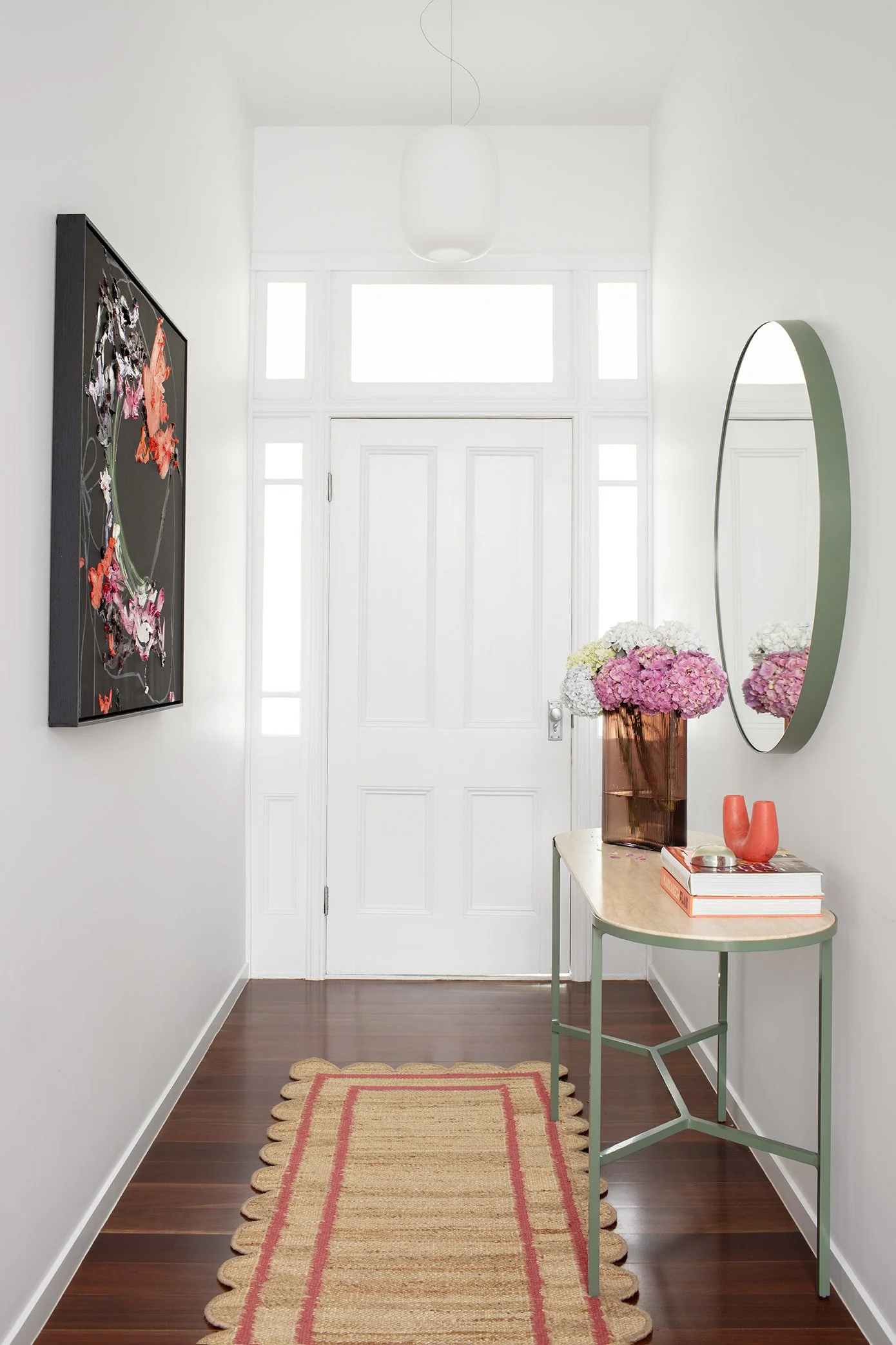 Colourful entryway in a Queenslander cottage featuring vibrant artwork, a fun entry runner, Australian-designed and made furniture, and a mix of playful hues