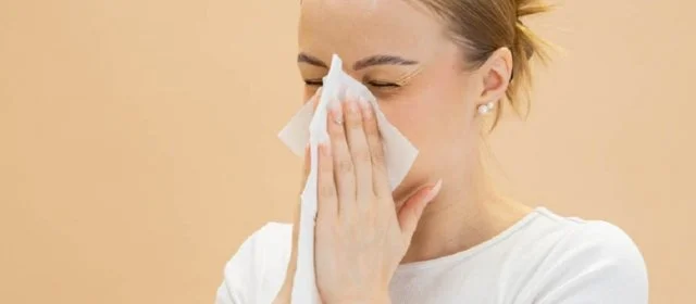 Ihminen niistää nenää