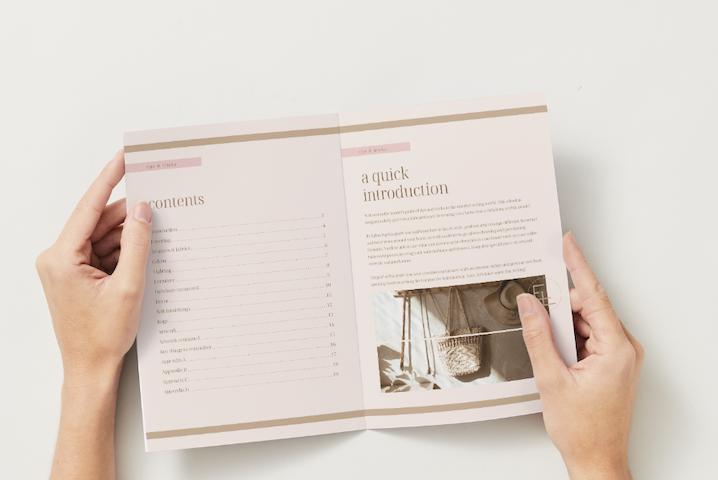 Person holding an open pamphlet or brochure with a table of contents on the left page and an introduction with a photo of an interior space on the right page.