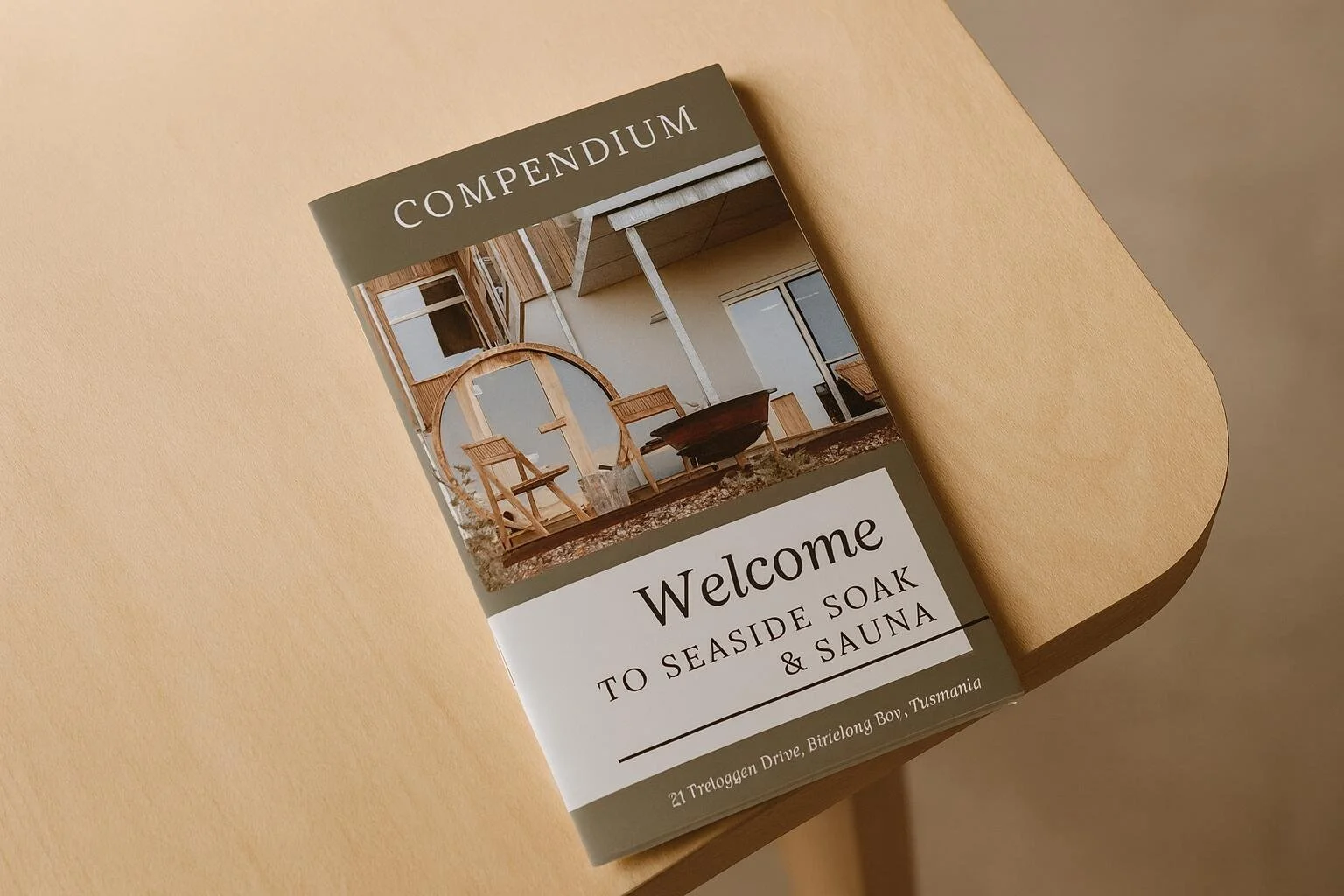 Brochure with welcoming message for seaside soak and sauna in Binalong Bay Tasmania, showing a modern wooden house with outdoor seating area.