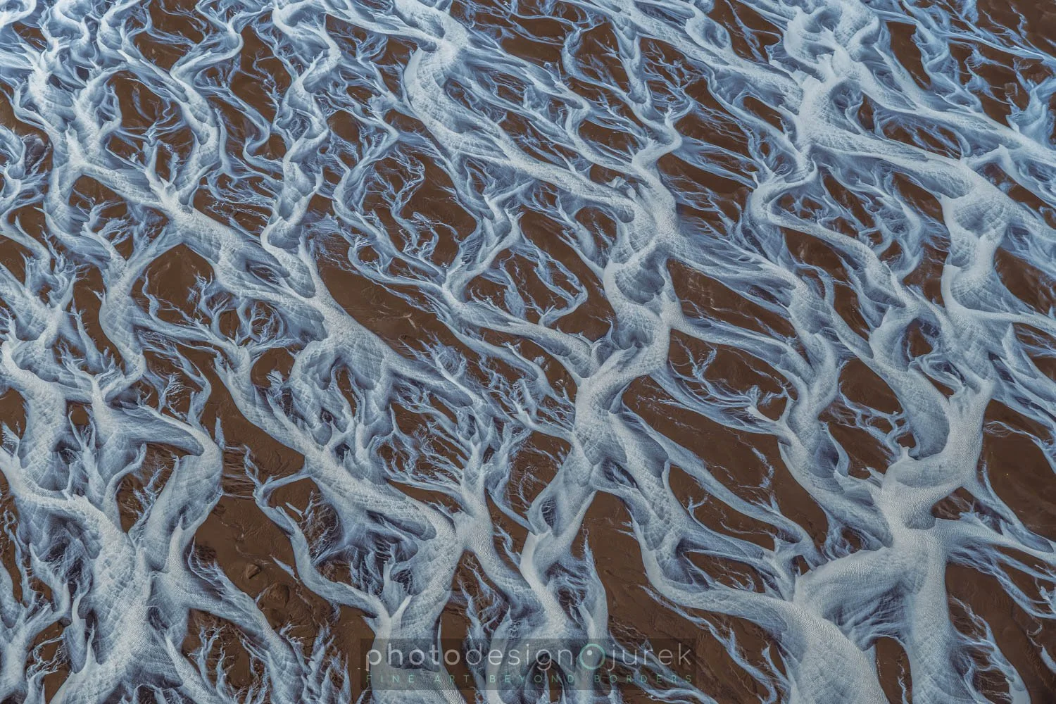 Aerial view of ocean waves washing onto sandy beach.