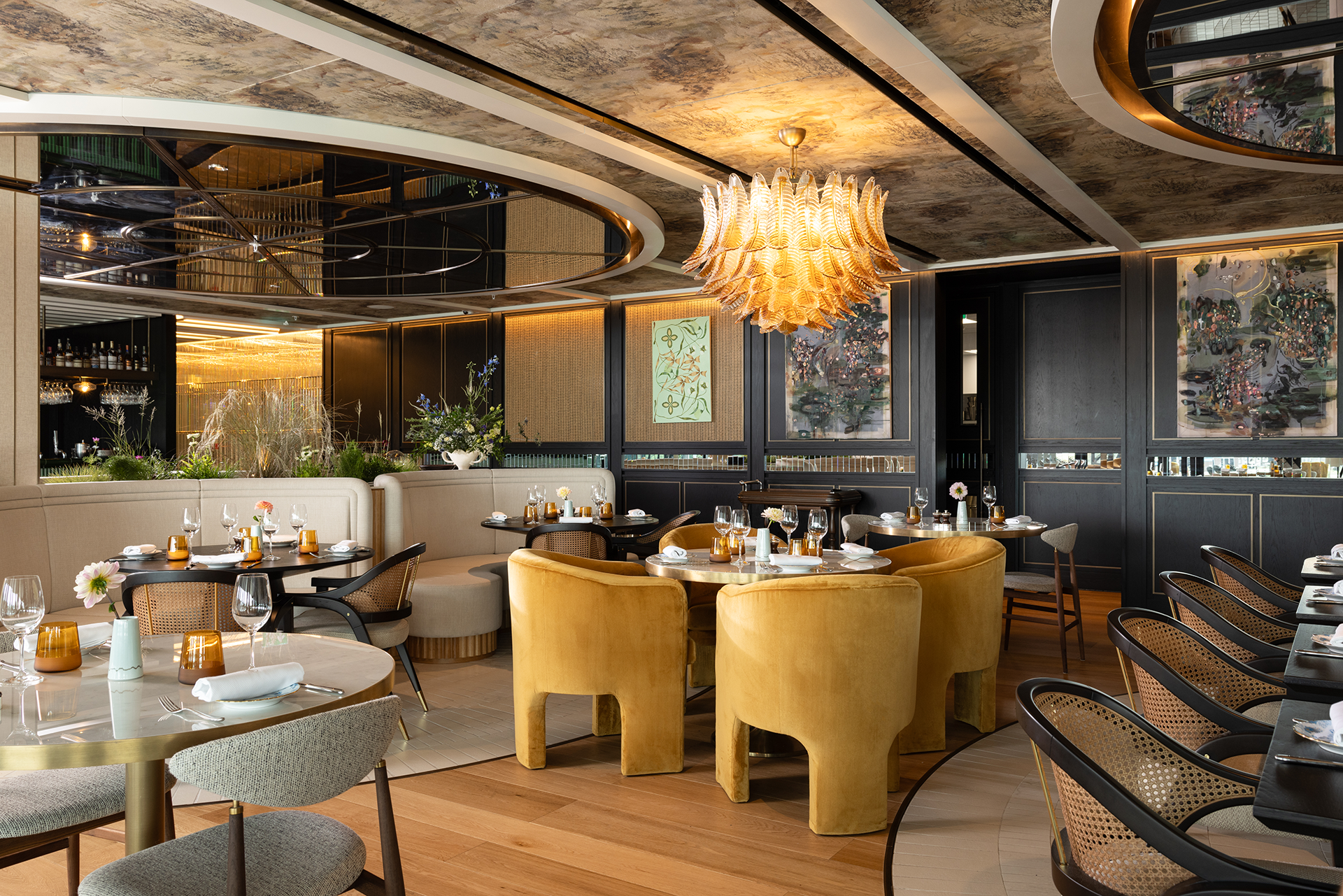 Constance Restaurant interior with elegant furniture, decorative lighting, and large windows overlooking greenery.