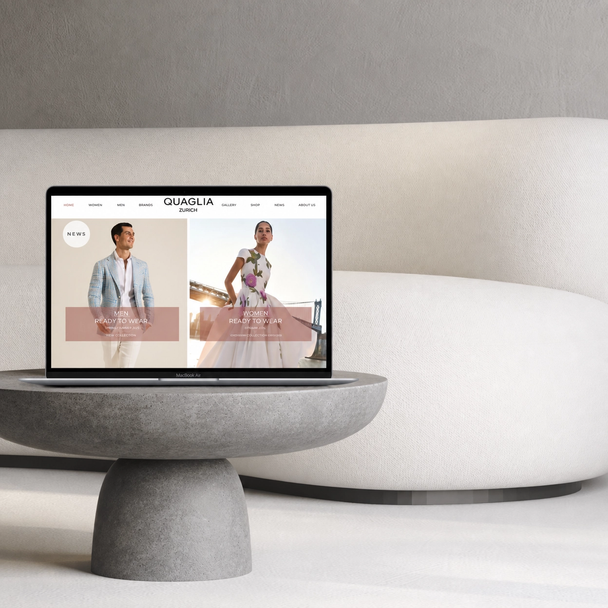 A laptop displaying an online fashion store website called Quaglia Zurich, with images of a man in a blazer and a woman in a colorful dress, set on a modern gray table in a minimalistic room.