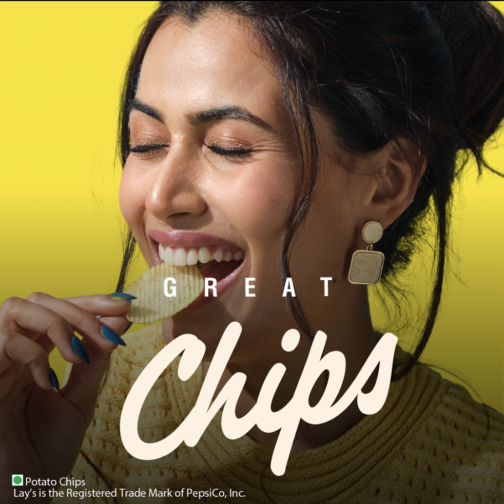 Ad campaign for Lay's India with a woman licking a potato chip against a yellow background, with text promoting potato chips.