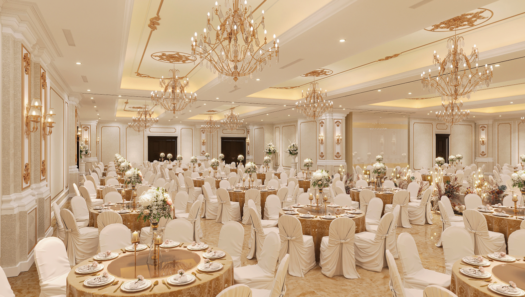 Elegant banquet hall with round tables covered in gold tablecloths, surrounded by white chairs with slipcovers and bows, decorated with floral centerpieces, candles, and fine china, chandeliers hanging from the ceiling.
