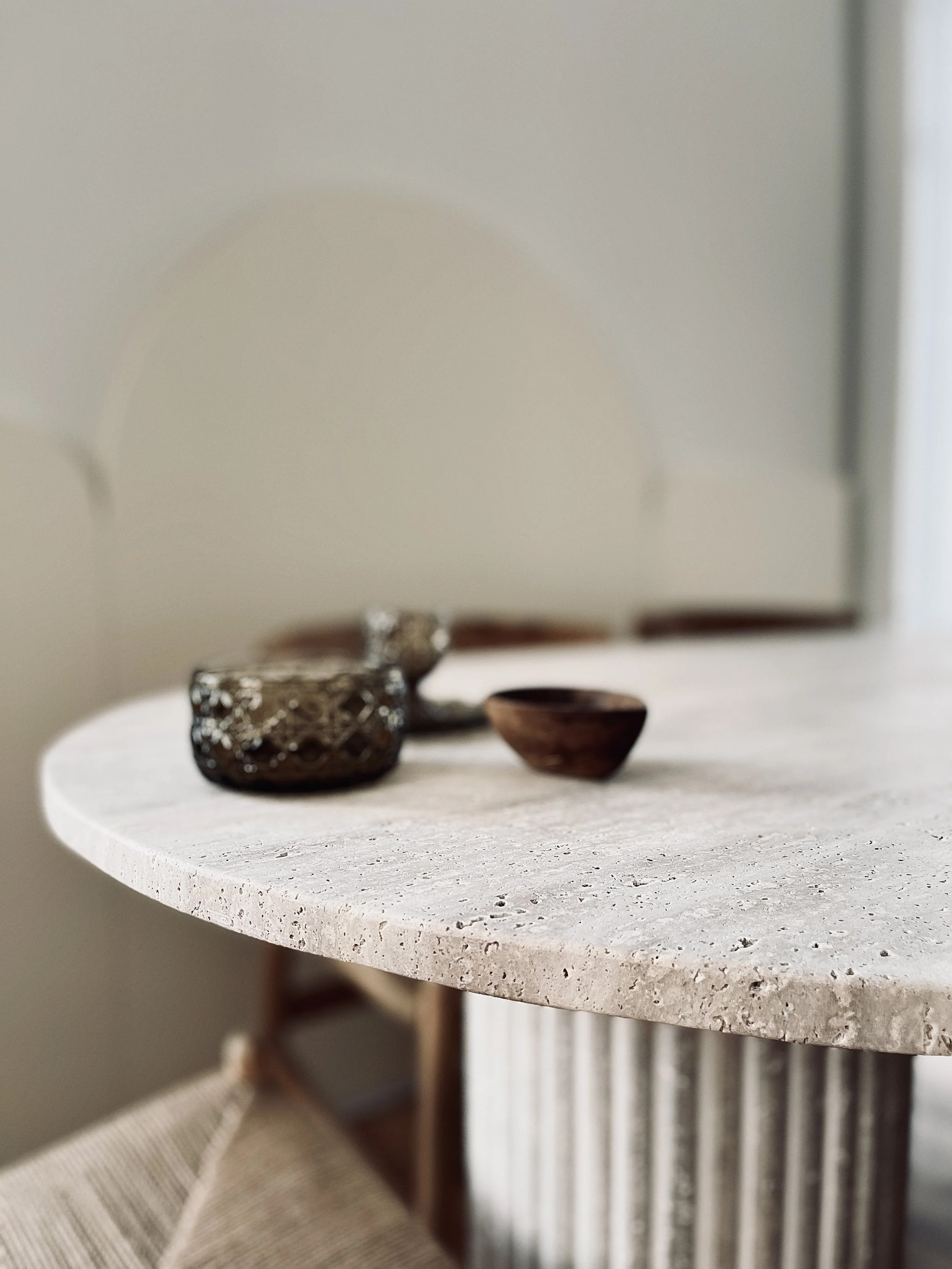 Détail du plateau et du pietement de la table en travertin.