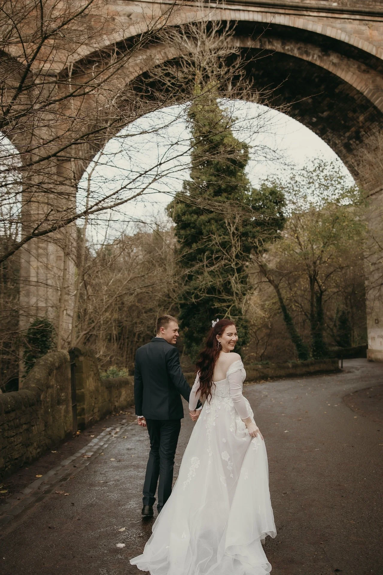 Bride and groom running together and laughing during their wedding day in Edinburgh