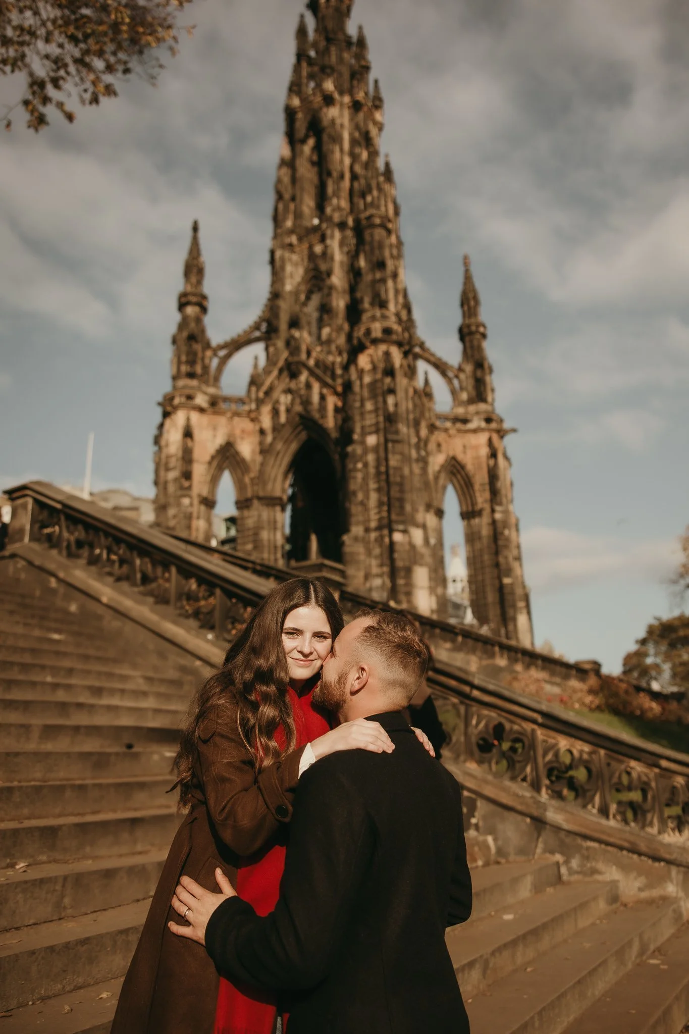 Proposal photoshoot in Edinburgh with couple walking hand in hand through historic streets