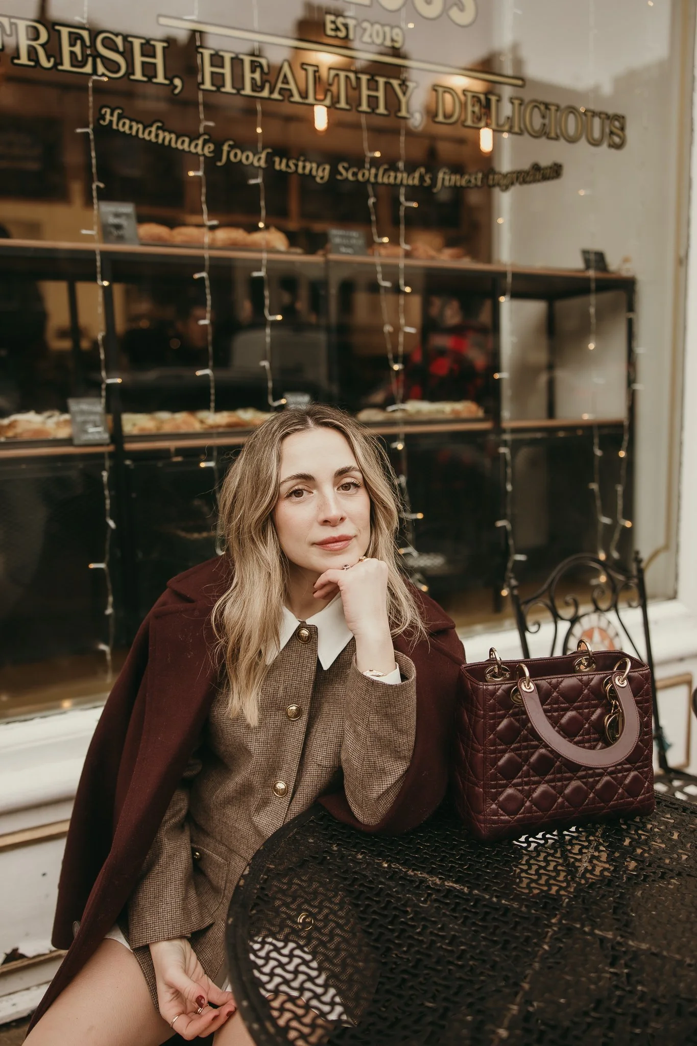 Solo female traveler walking in soft morning light in Edinburgh during a professional portrait session.