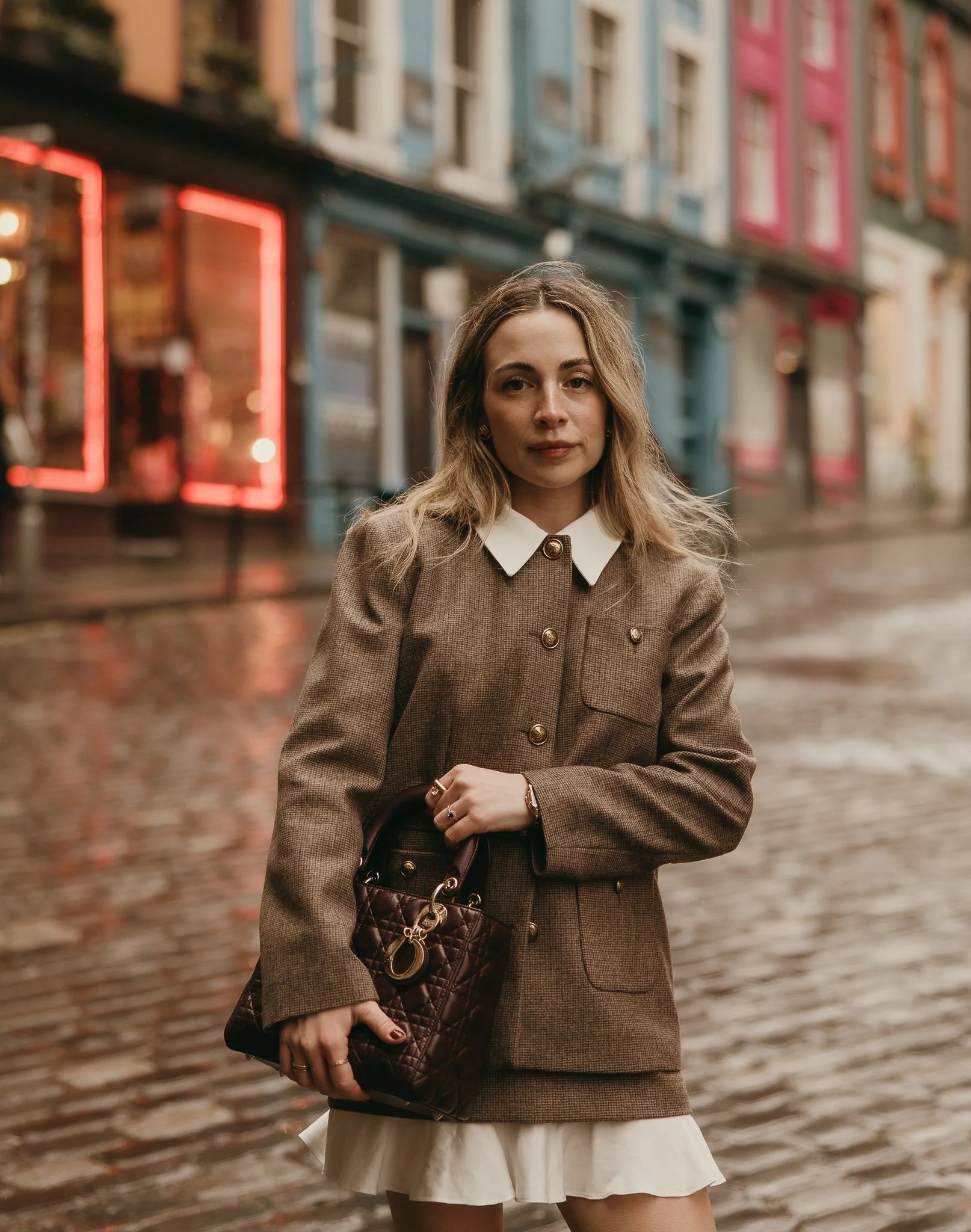 Woman running through the cobbled streets of Edinburgh during a joyful solo photoshoot.