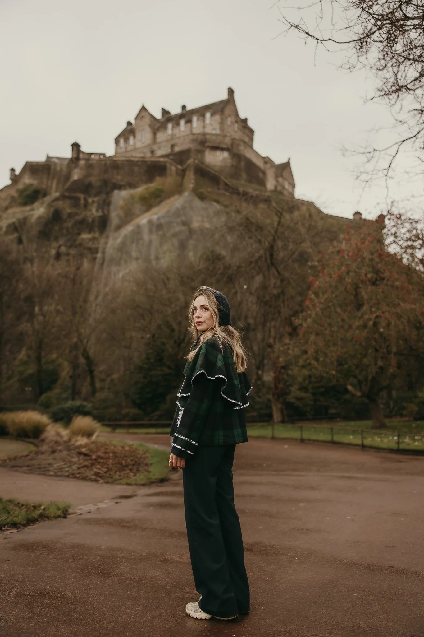 Female tourist walking past historic buildings in Edinburgh.
