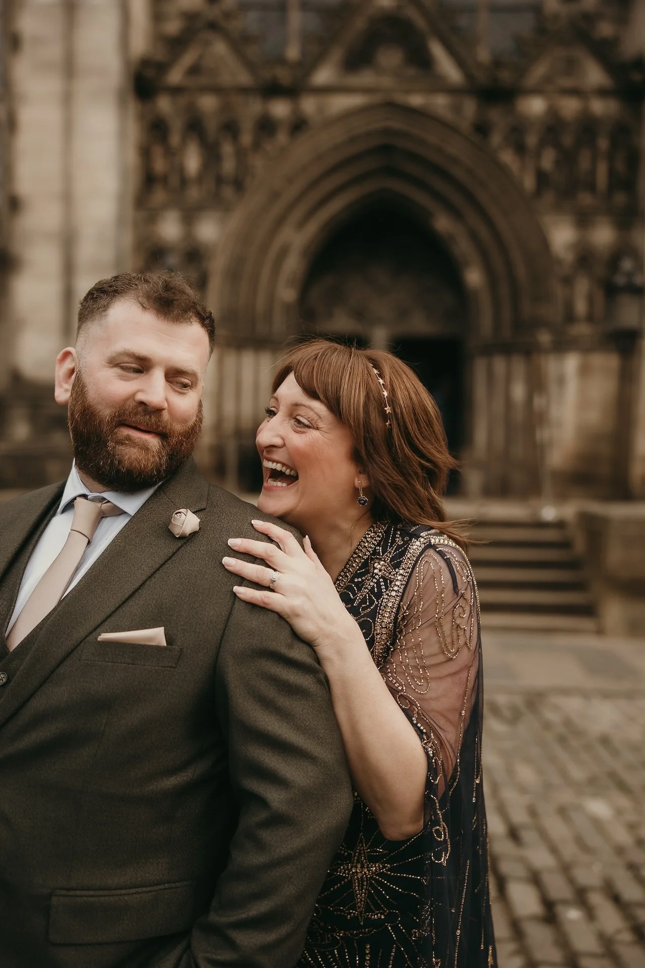 Playful moment of bride and groom running together during an Edinburgh wedding