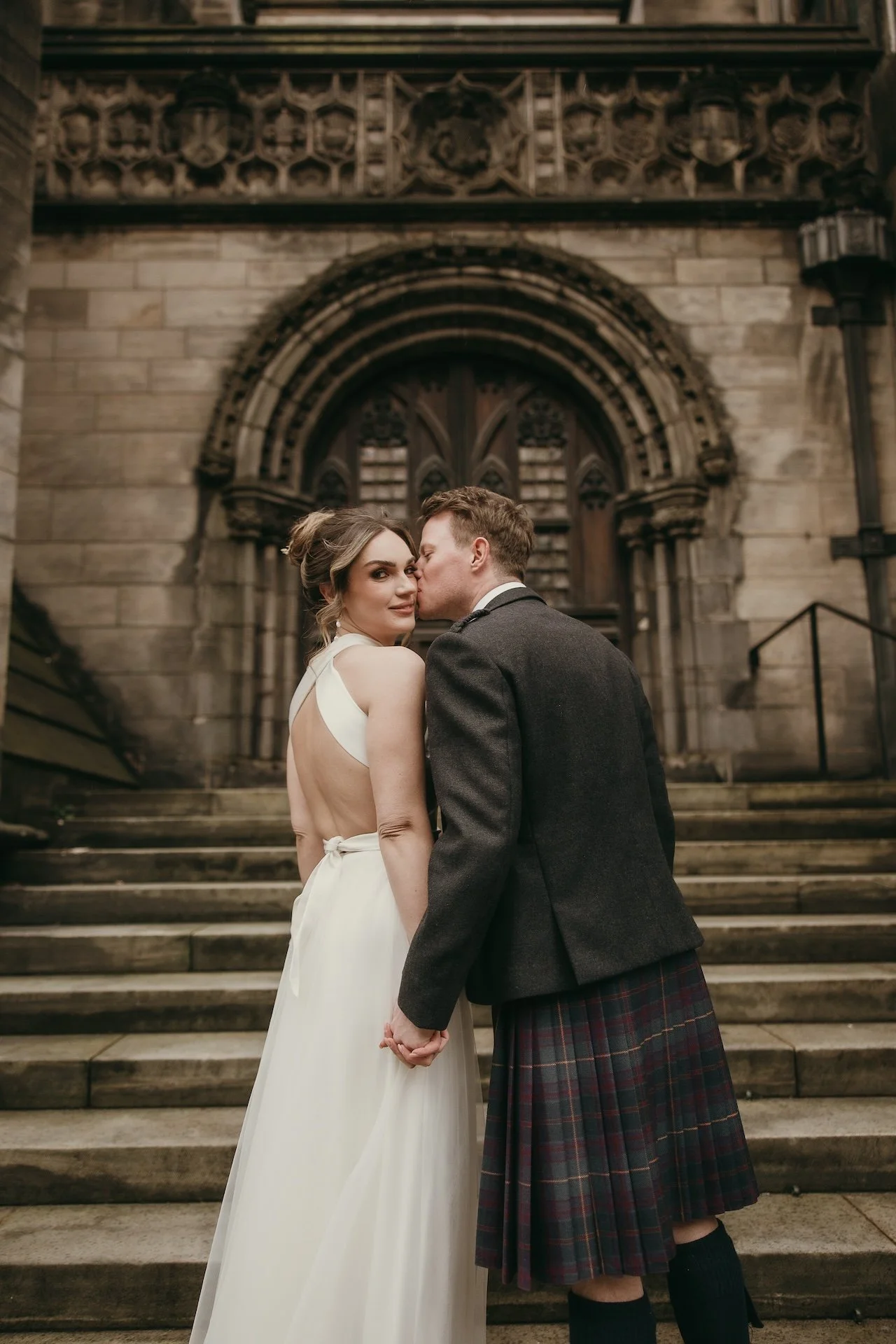 ride and groom sharing a warm hug on their wedding day in Edinburgh