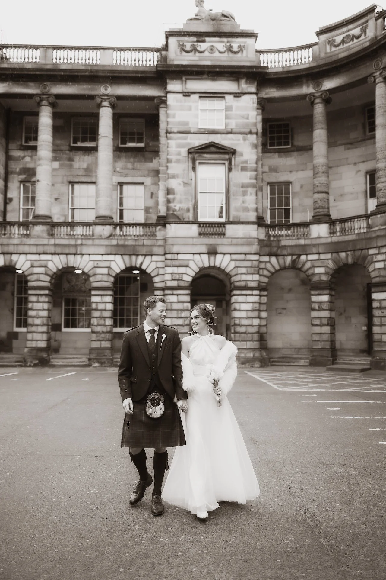 Bride and groom walking hand in hand through Edinburgh on their wedding day