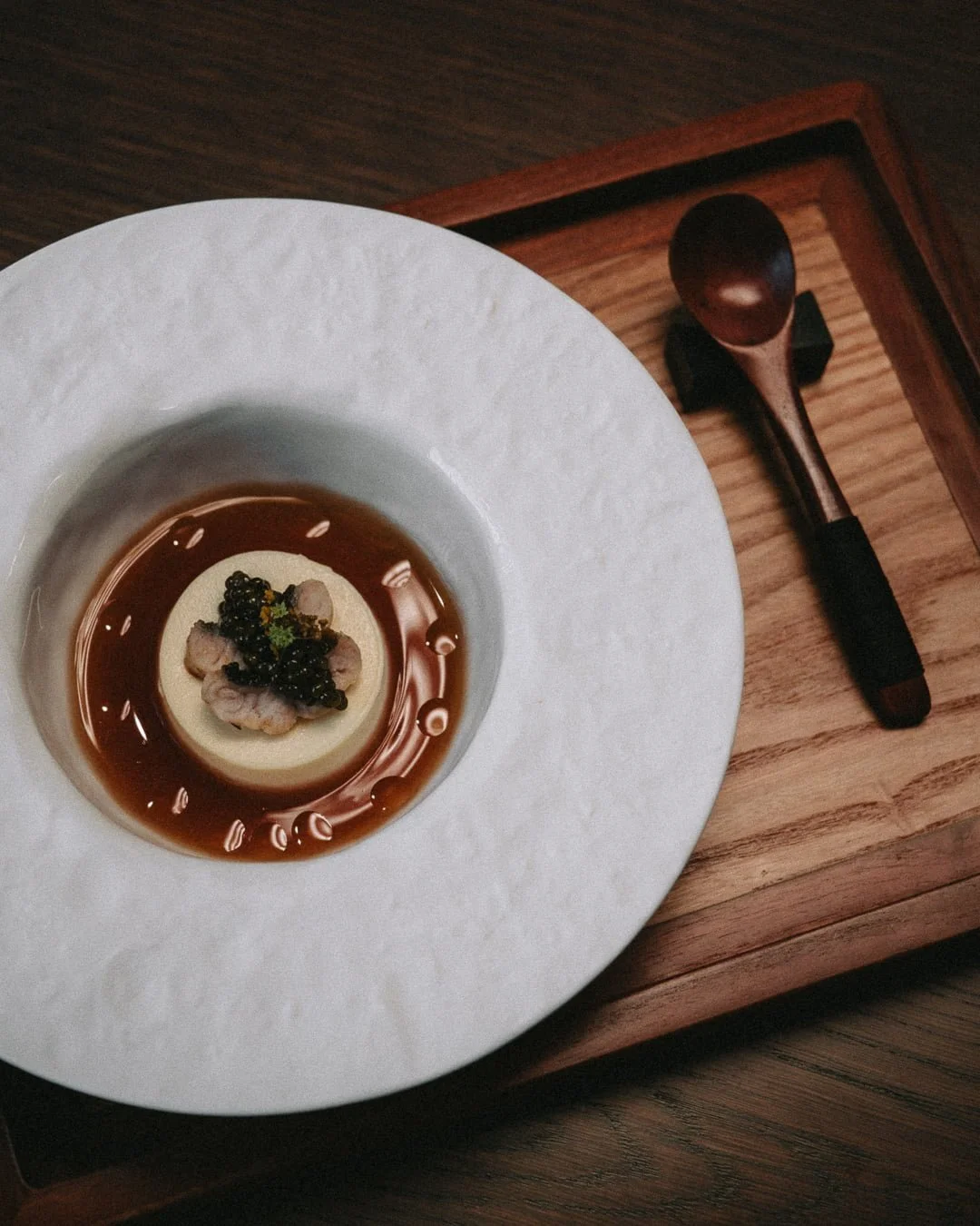 smith, fine dining, chawanmushi in weißem teller auf braunem holztablett, ein holzlöffel angelegt