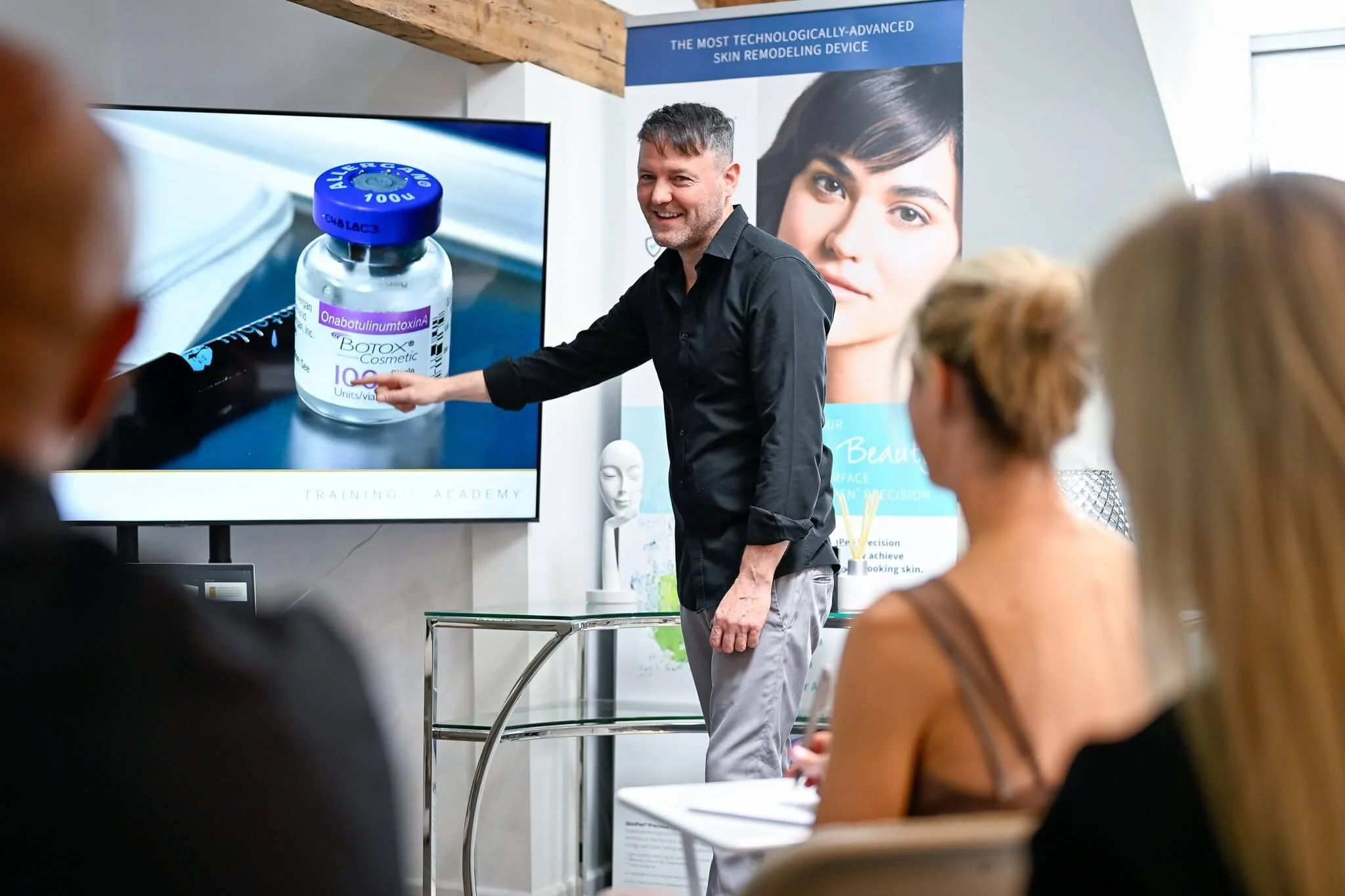 Trainer presenting Botox vial slide during an aesthetic training session at the academy.