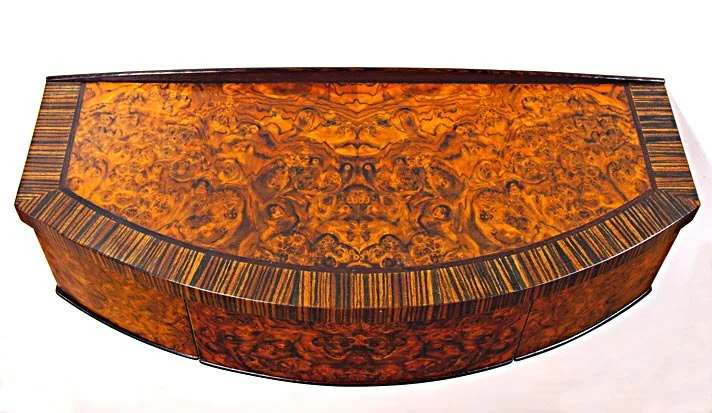 Decorative wooden table with a burled wood pattern and striped edges.
