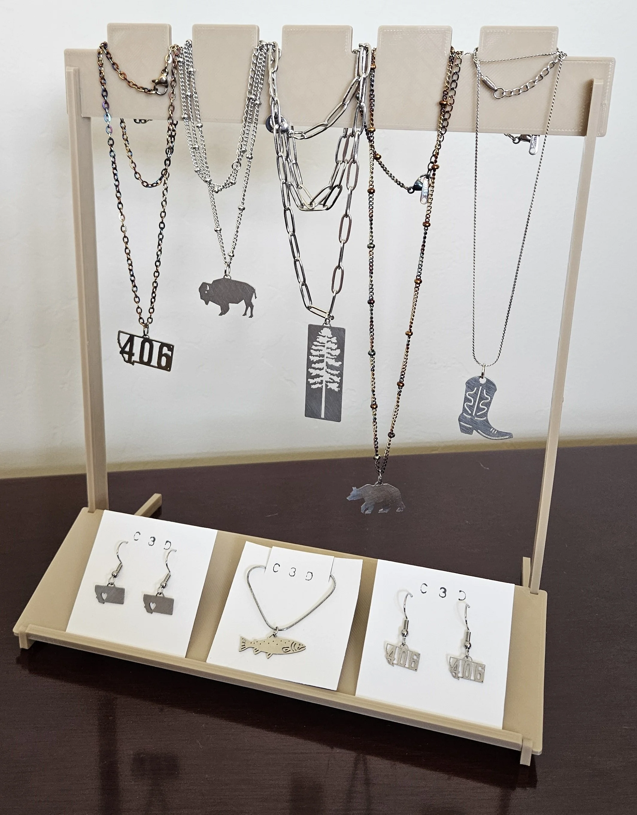 Jewelry stand FDM 3D printed part with necklaces and earrings.