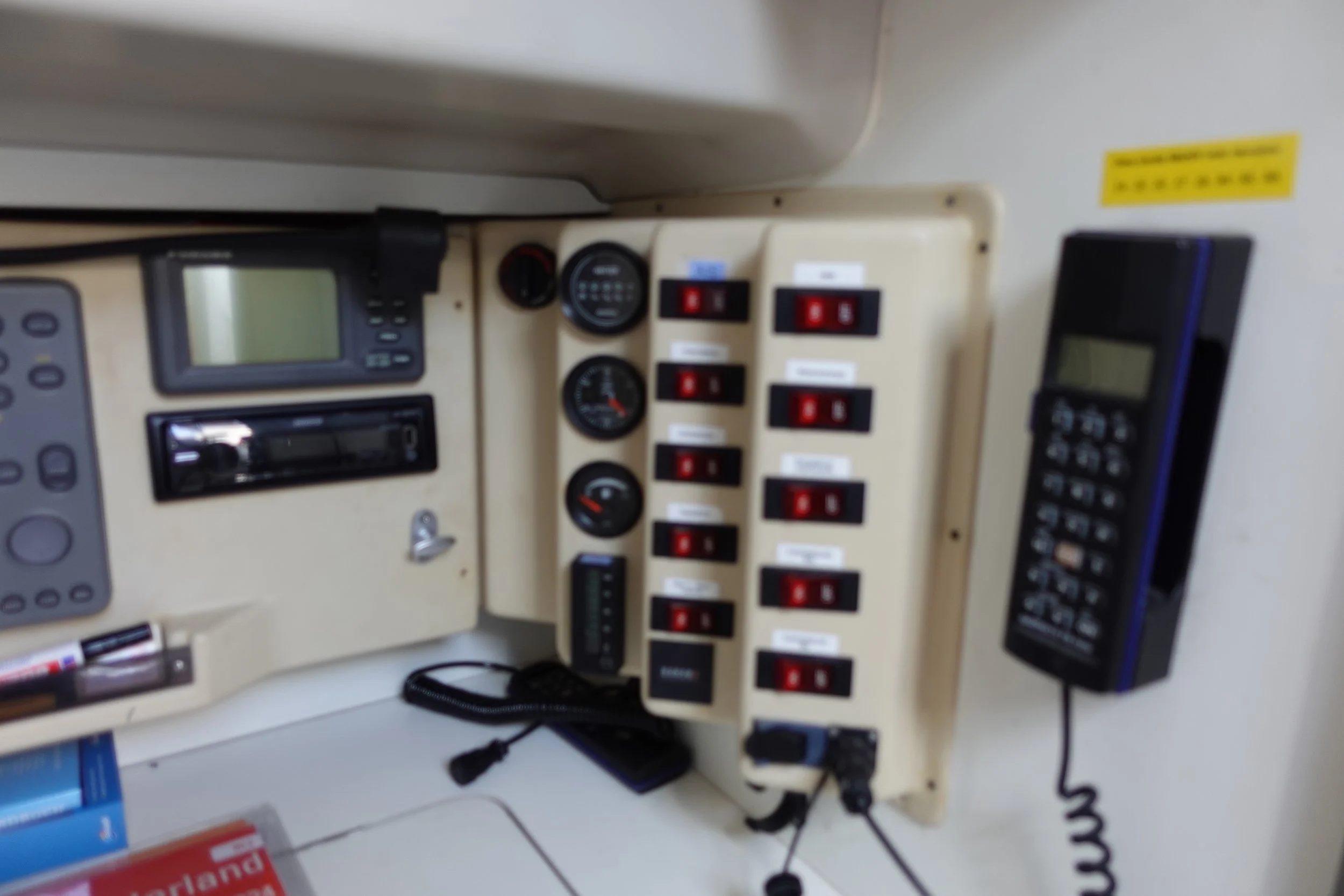 Een bedieningspaneel met diverse schakelaars, meters, telefoons en elektronische apparaten.