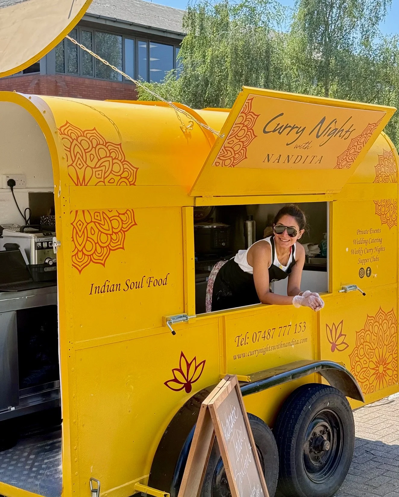 Curry nights van with friendly lady preparing to serve festival goers with delicious curries, wraps and other Indian soul food