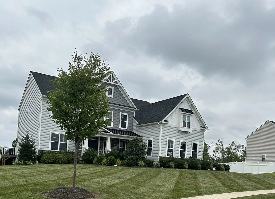 Modern suburban house with grey siding and manicured lawn