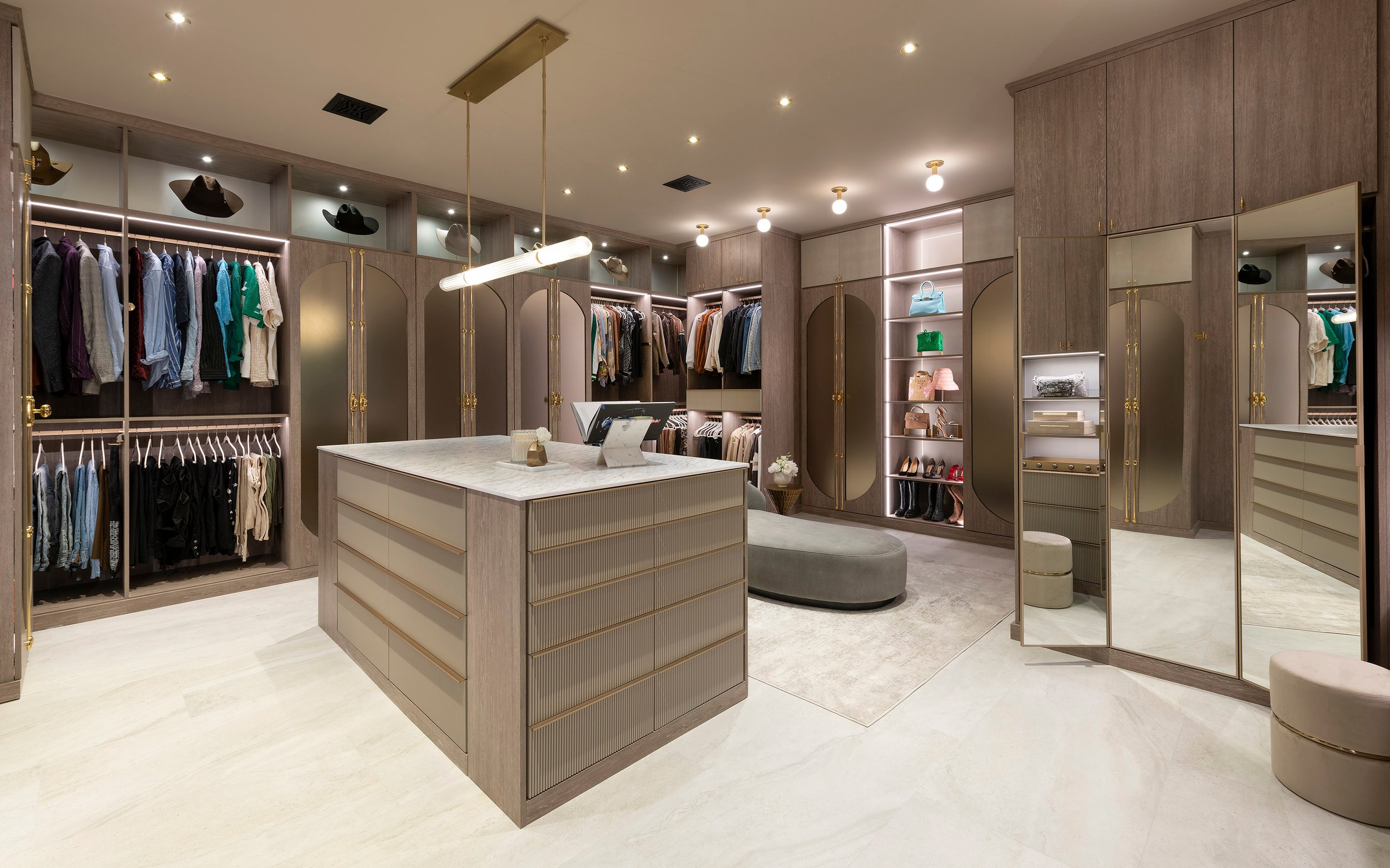 Modern his and hers walk-in closet with island and pendant lighting