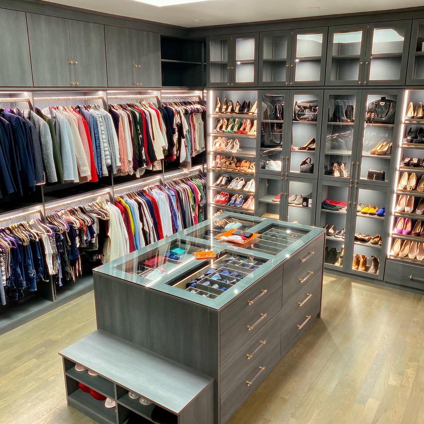 Gray walk-in closet with center island, shoe wall and hanging storage